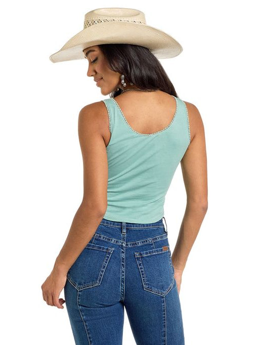 Woman wearing blue jeans and a light green tank top with a white background