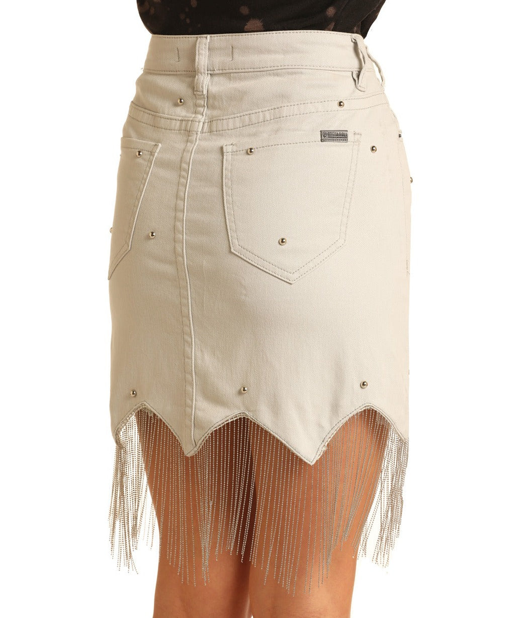 The Chain Mini Skirt by Rock & Roll Denim is a light beige high-rise denim skirt with silver studs, scalloped hem, long silver chain fringe, back view shown with two pockets, and a fitted waist.