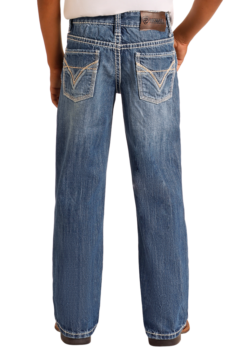 A person stands facing away, wearing Rock & Roll Denim Boys' Ivory Top-Stitching Regular Fit Bootcut Jeans in faded blue with decorative back pockets and a brown leather brand patch on the waistband.