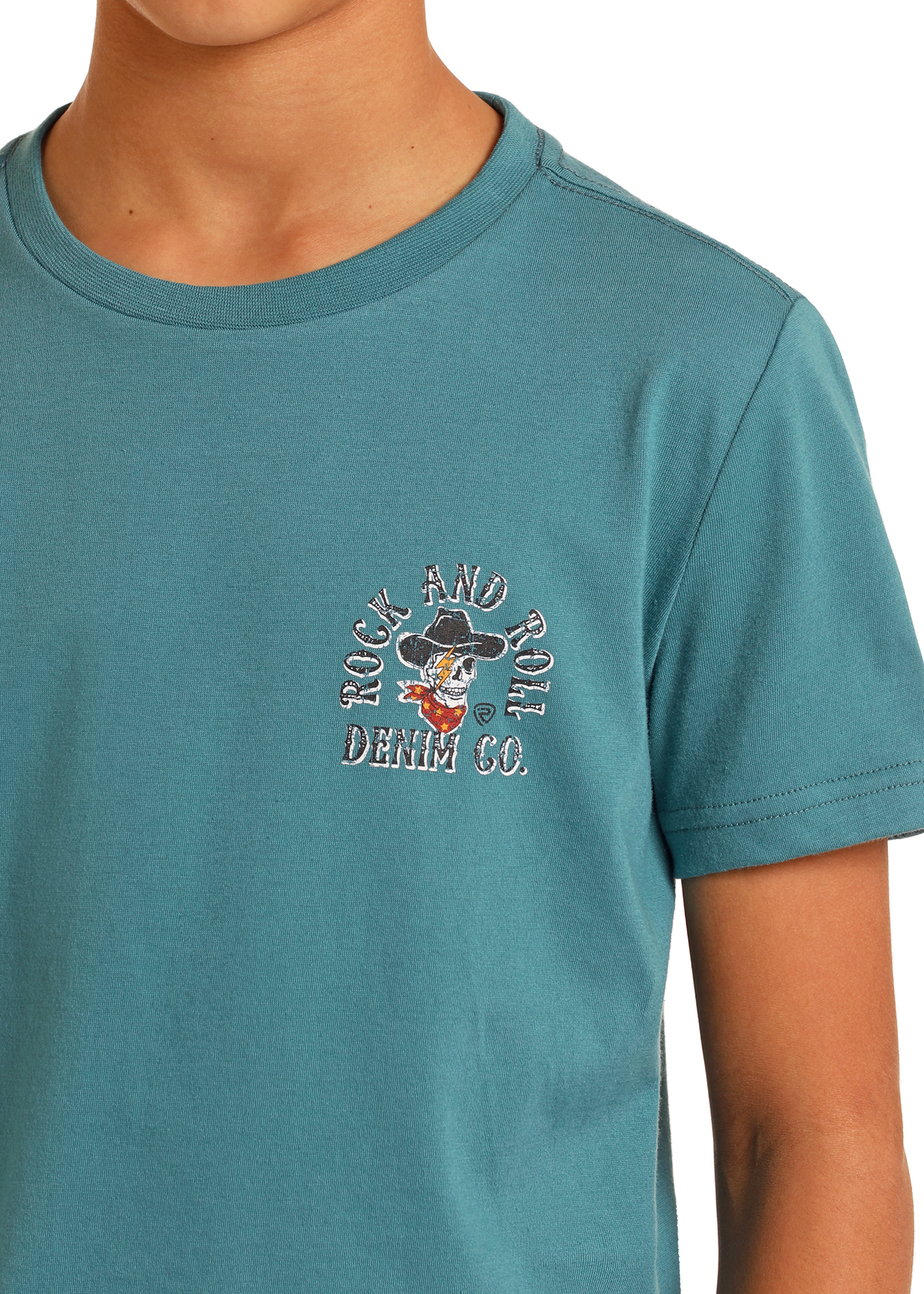 A boy wears the Rock & Roll Denim Boys' Western Spirit Graphic Tee, a teal regular-fit shirt with short sleeves and a small left-chest graphic of a cartoon duck in a hat and "Rock and Roll Denim Co." text.