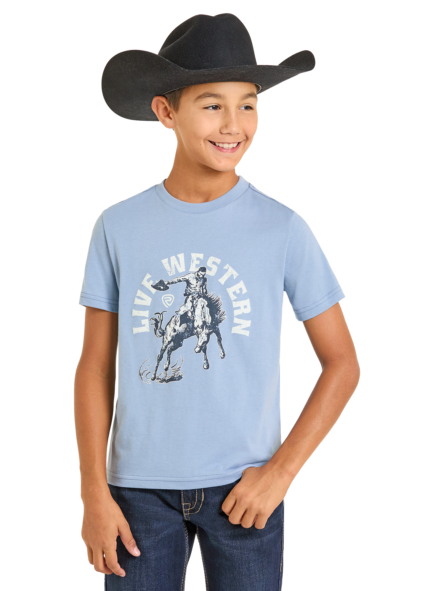 A smiling boy in a black cowboy hat, jeans, and a Rock & Roll Denim Boys' Live Western Graphic Tee stands with one hand in his pocket against a plain white background.