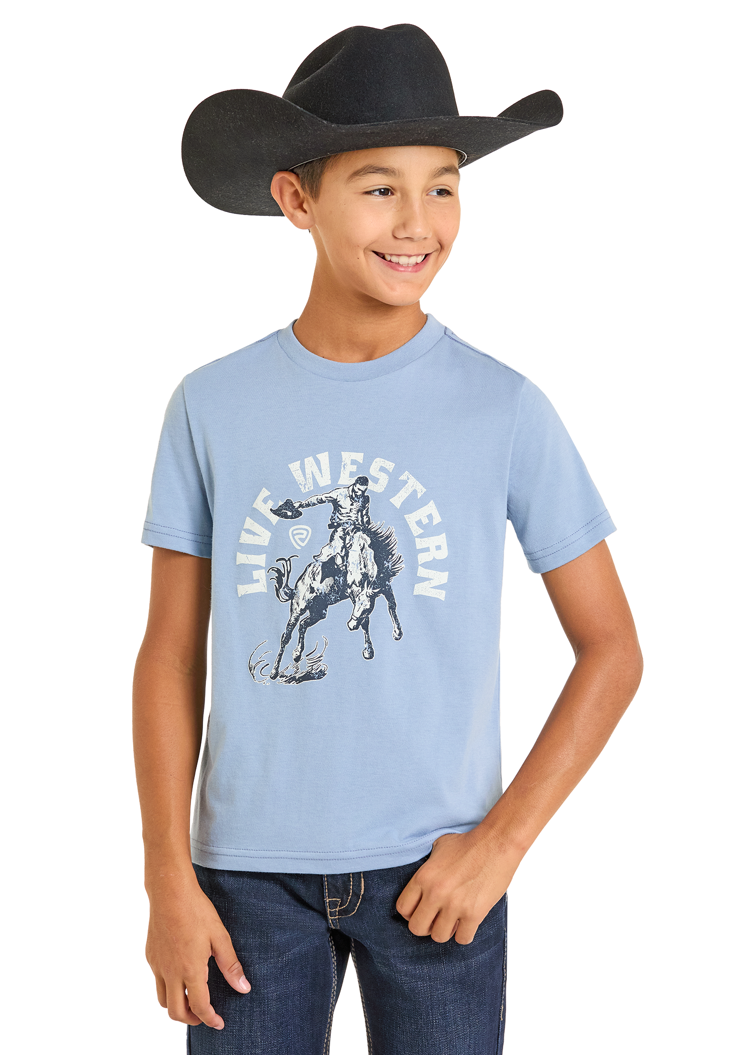 A smiling boy in a black cowboy hat, jeans, and a Rock & Roll Denim Boys' Live Western Graphic Tee stands with one hand in his pocket against a plain white background.
