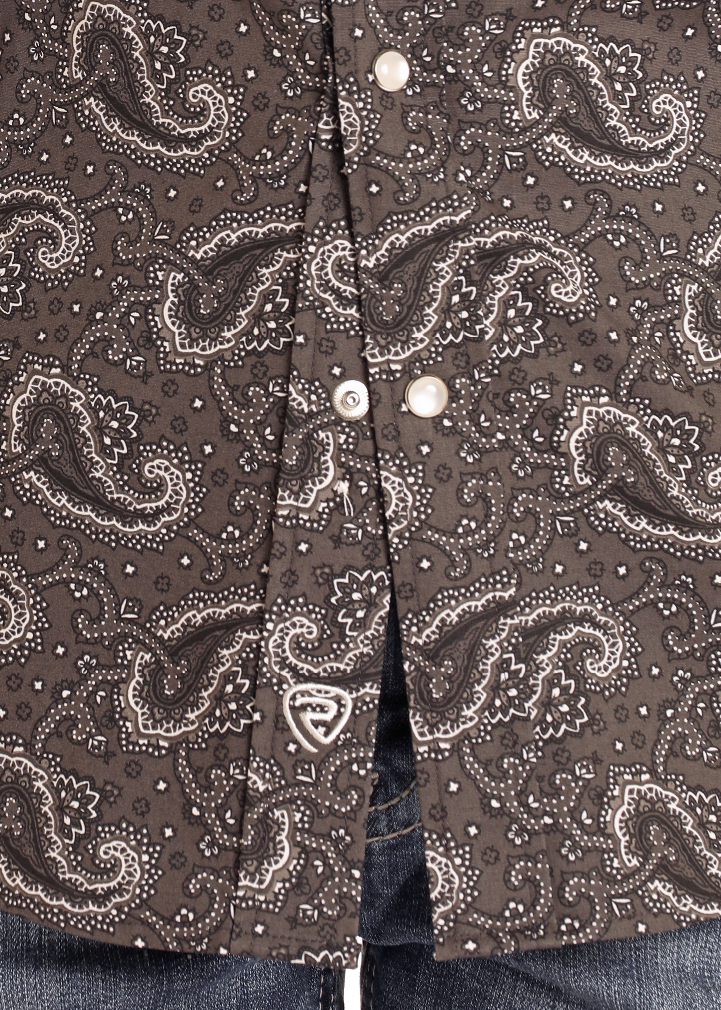Close-up of the Boys' Paisley Long Sleeve Snap Shirt by Rock & Roll Denim, featuring a white paisley print and pearl-like snaps, styled over blue jeans for a modern, stylish look.