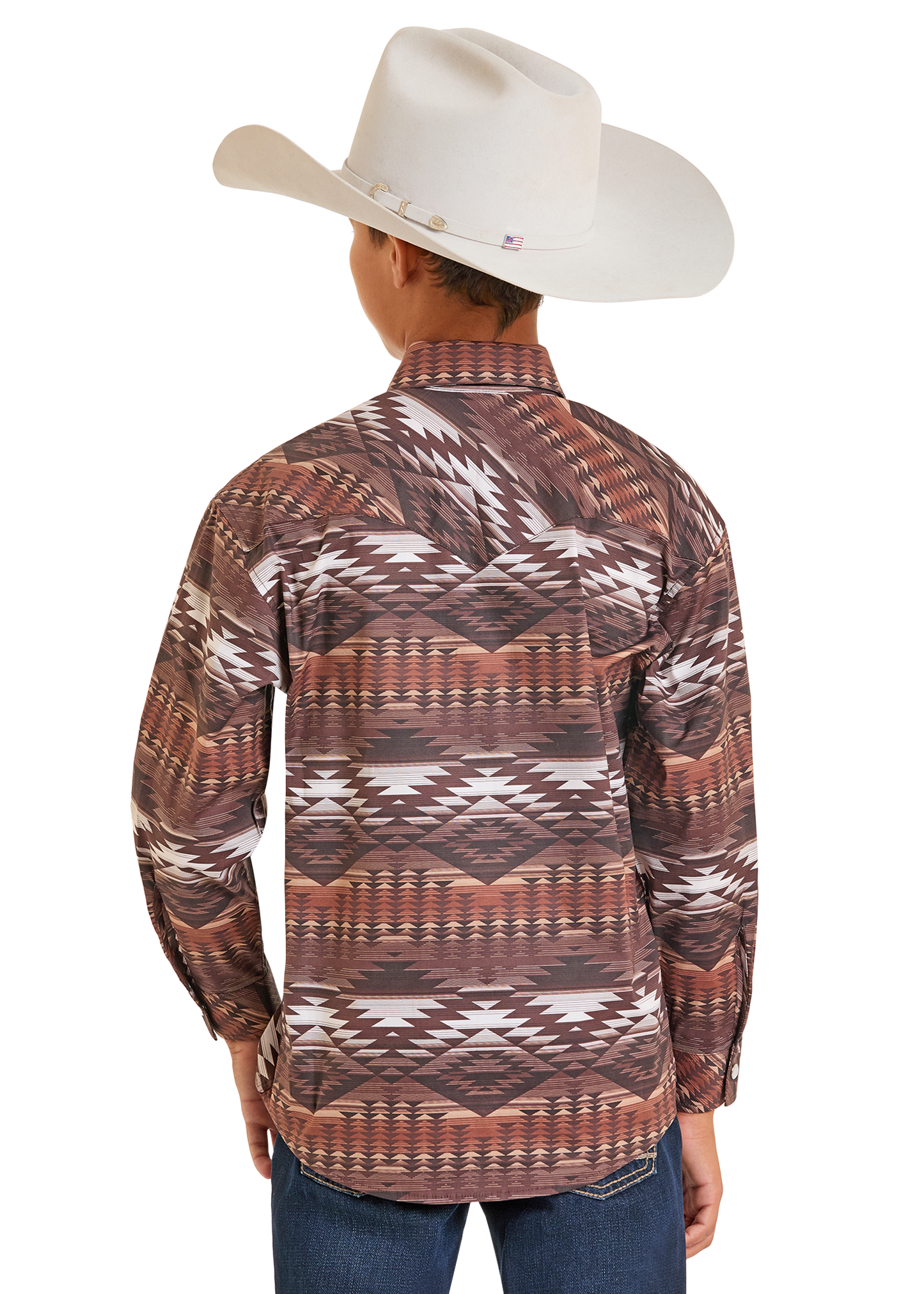 A person shown from the back against a plain white background wears a white cowboy hat, blue jeans, and a Rock & Roll Denim Boys' Brown Aztec Long Sleeve Snap Shirt.