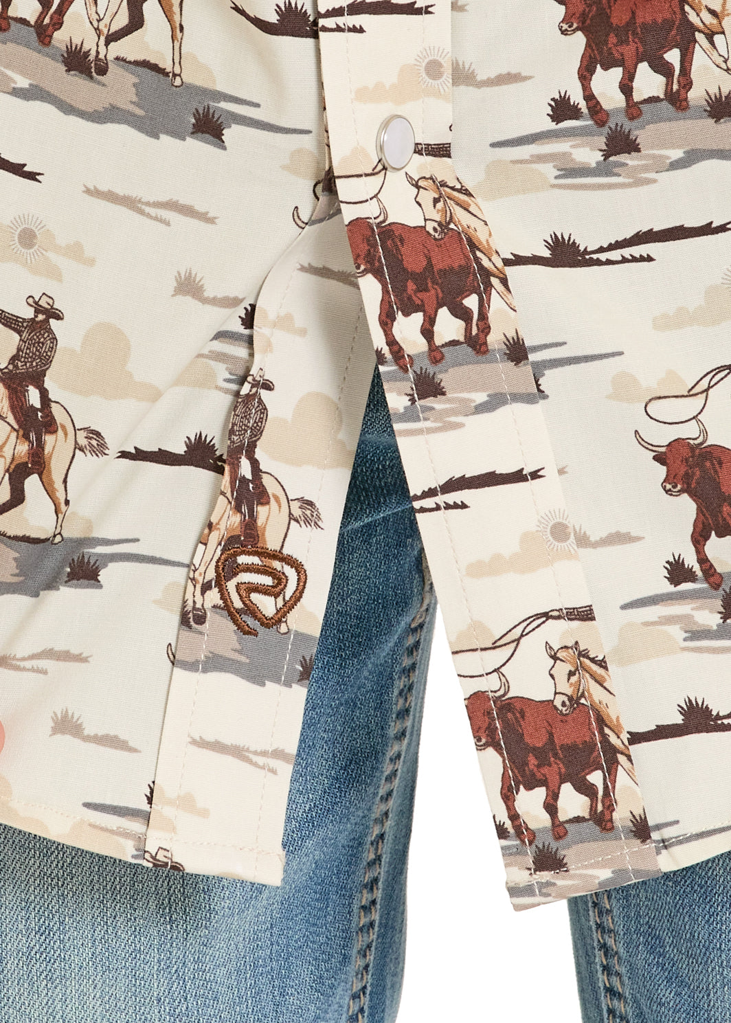 Close-up of a shirt with a cowboy and cow pattern on a beige background.