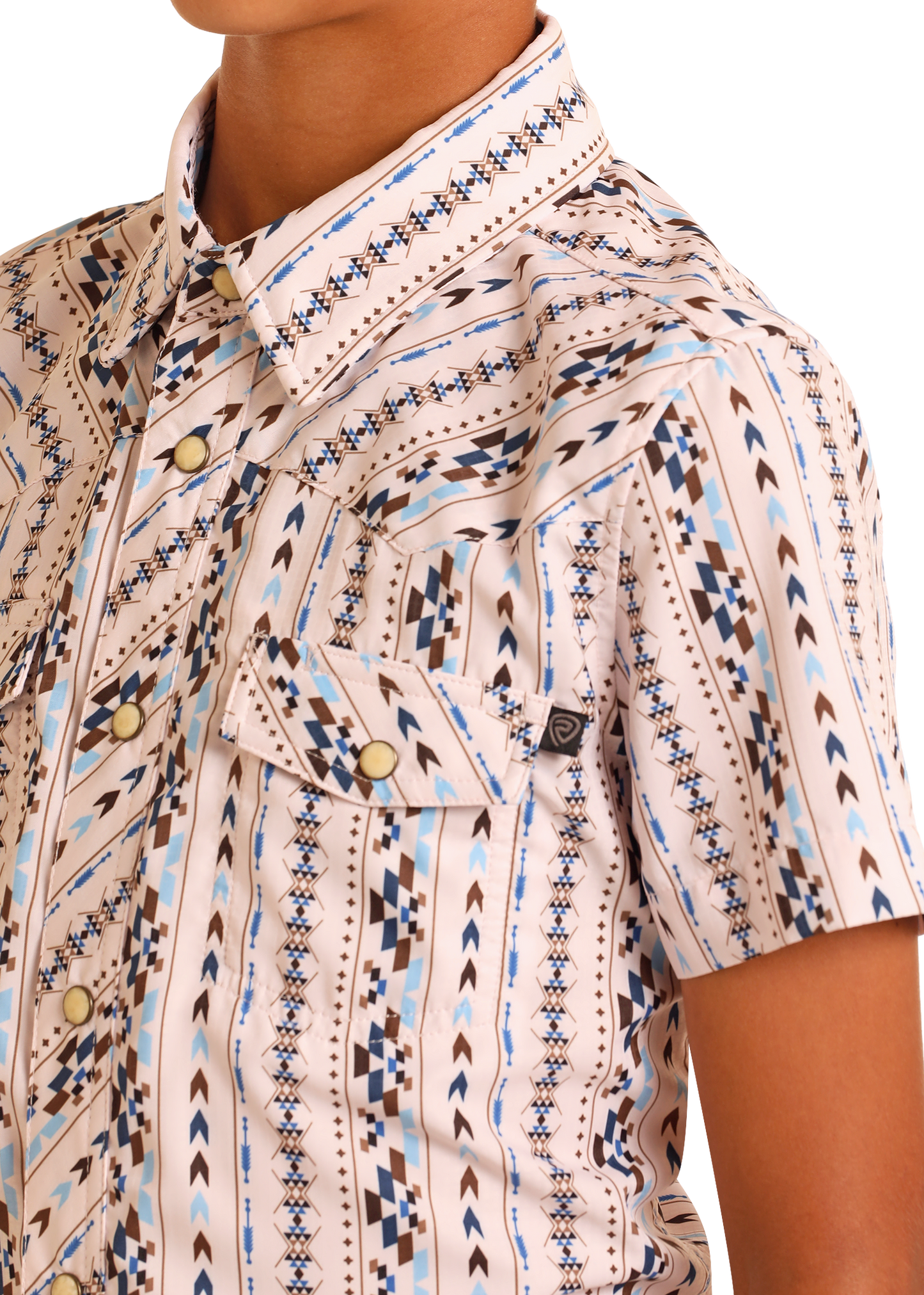 The Boys' TEK Western Striped Aztec Short Sleeve Shirt by Rock & Roll Denim features a geometric pattern in light blue, beige, and black with a front pocket, flap, and metal snap buttons. The wearer’s face is not visible.