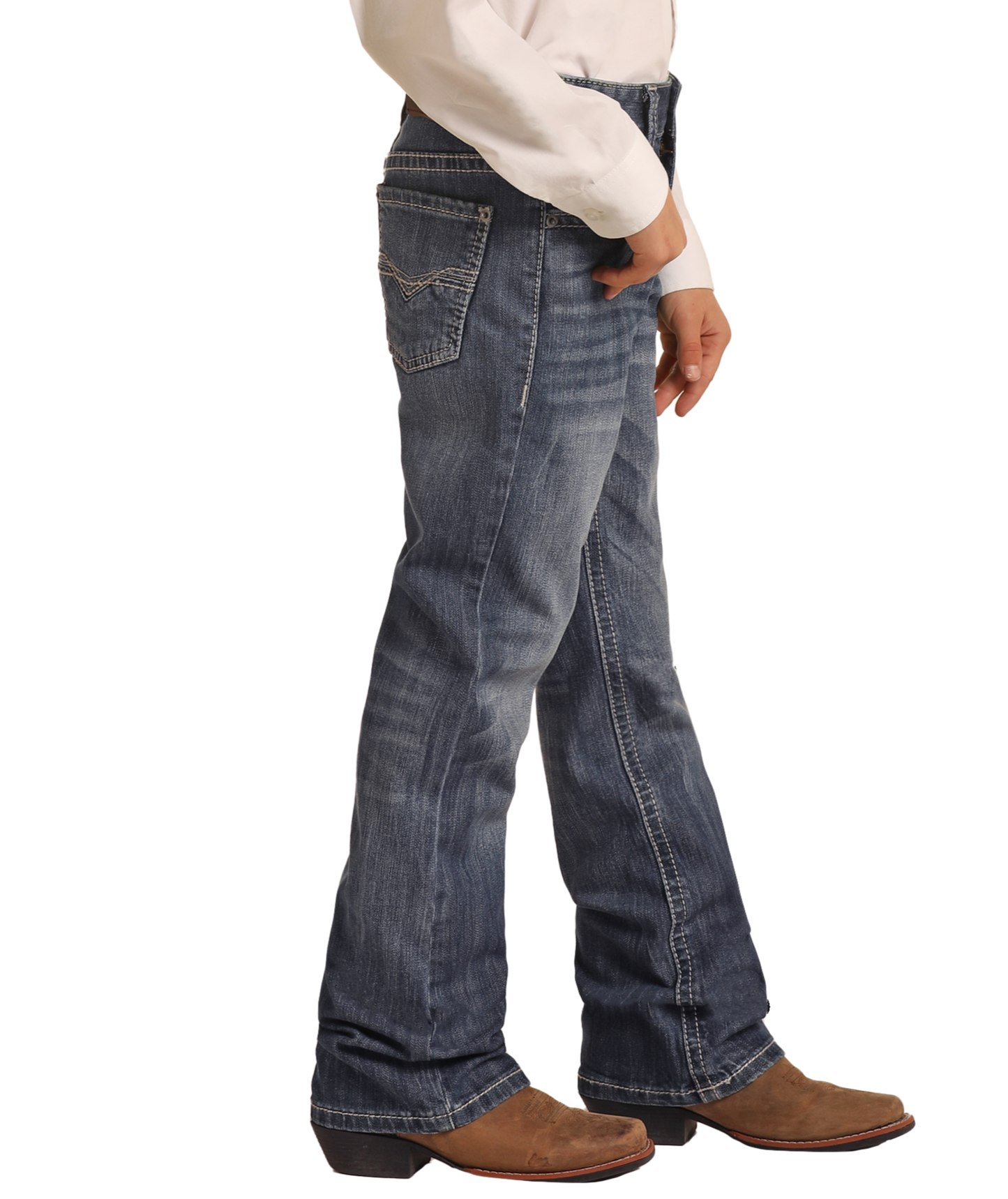 A boy models Rock & Roll Denim Boys' Regular Fit Light Grey Top-Stitching Bootcut Jeans, paired with a white long-sleeve shirt and brown cowboy boots, standing sideways against a plain white background.