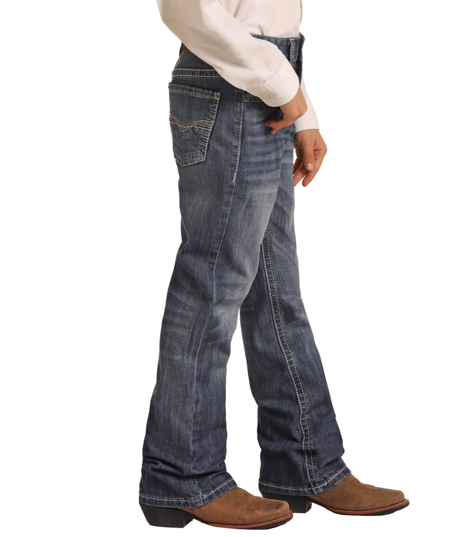 A boy models Rock & Roll Denim Boys' Regular Fit Light Grey Top-Stitching Bootcut Jeans, paired with a white long-sleeve shirt and brown cowboy boots, standing sideways against a plain white background.