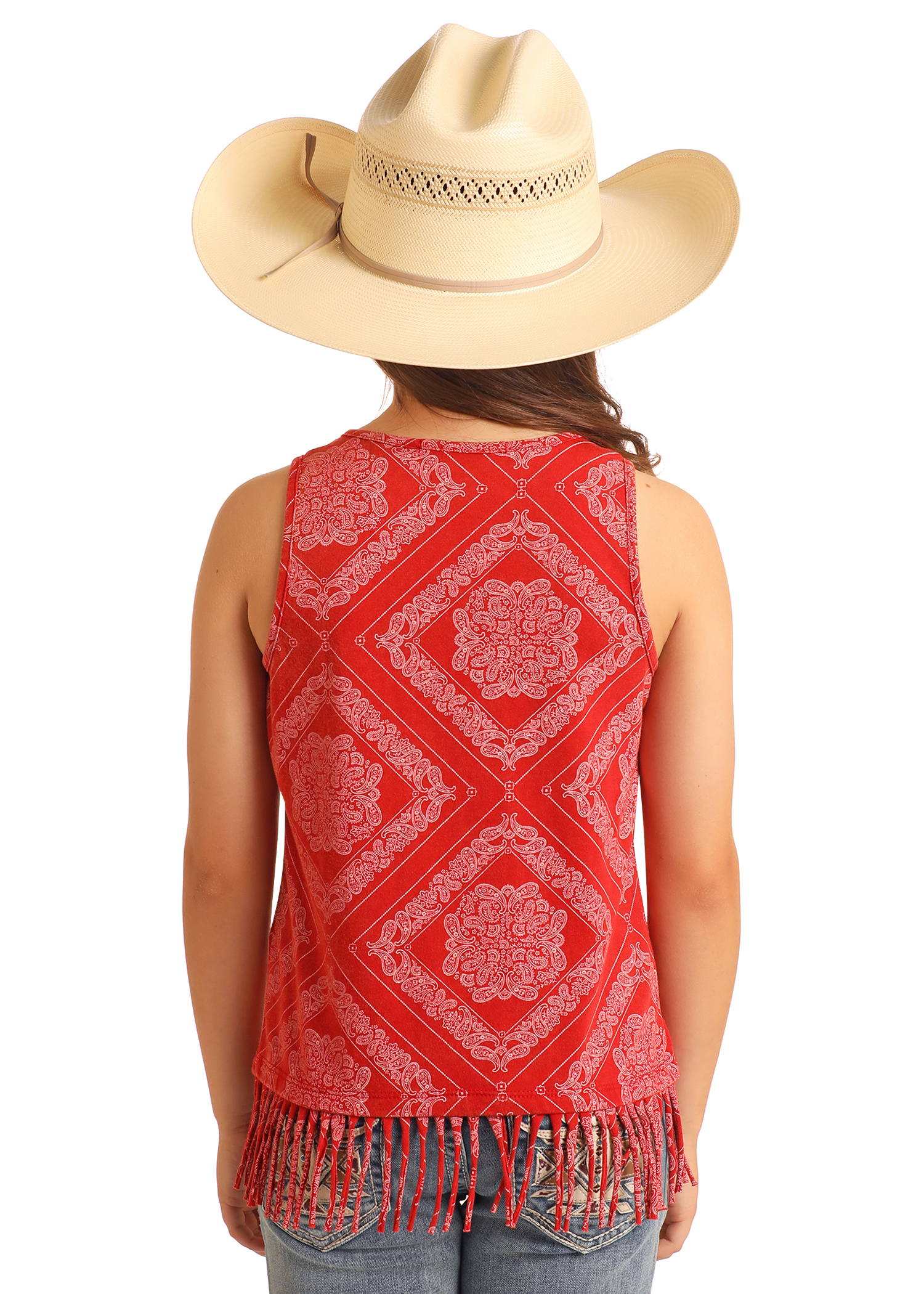A person wearing a large beige cowboy hat and a Rock & Roll Denim Girls' Bandana Fringe Tank, featuring a sleeveless red design with white paisley print and fringe hem, stands facing away, displaying the tank's back along with blue jeans.