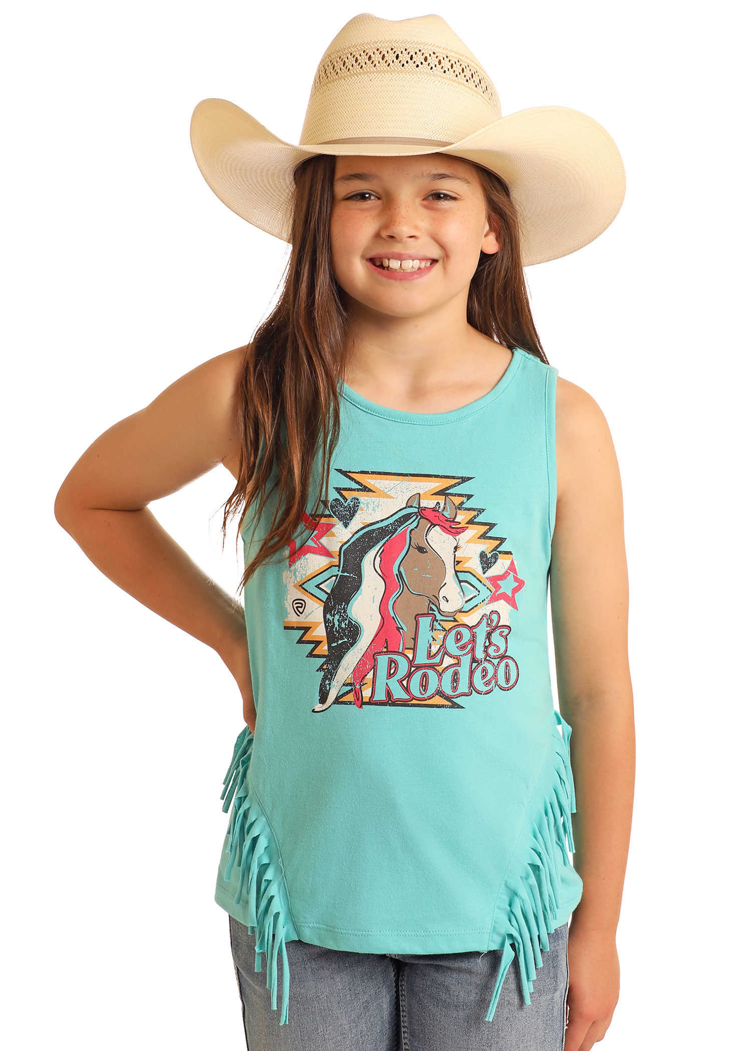 A smiling girl in a cowboy hat wears the Rock & Roll Denim Girls' Let's Rodeo Fringe Tank, featuring turquoise fabric, fringe details, and a colorful graphic, paired with blue jeans against a plain background.