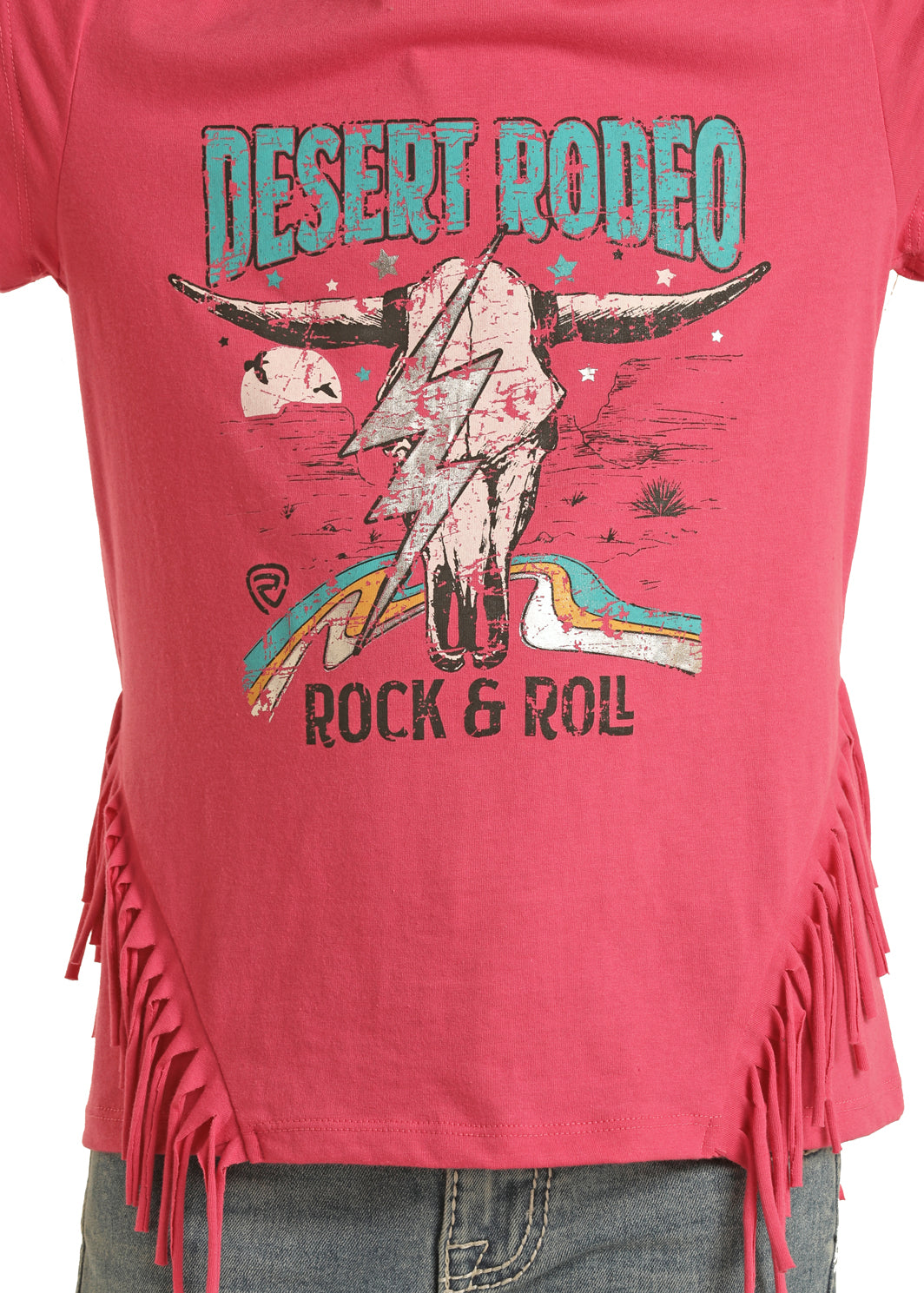 The Rock & Roll Denim Girls' Desert Rodeo Fringe T-Shirt features pink fabric, side fringe, a lightning skull and desert scene graphic, with "DESERT RODEO ROCK & ROLL" text—perfect to pair with blue jeans.