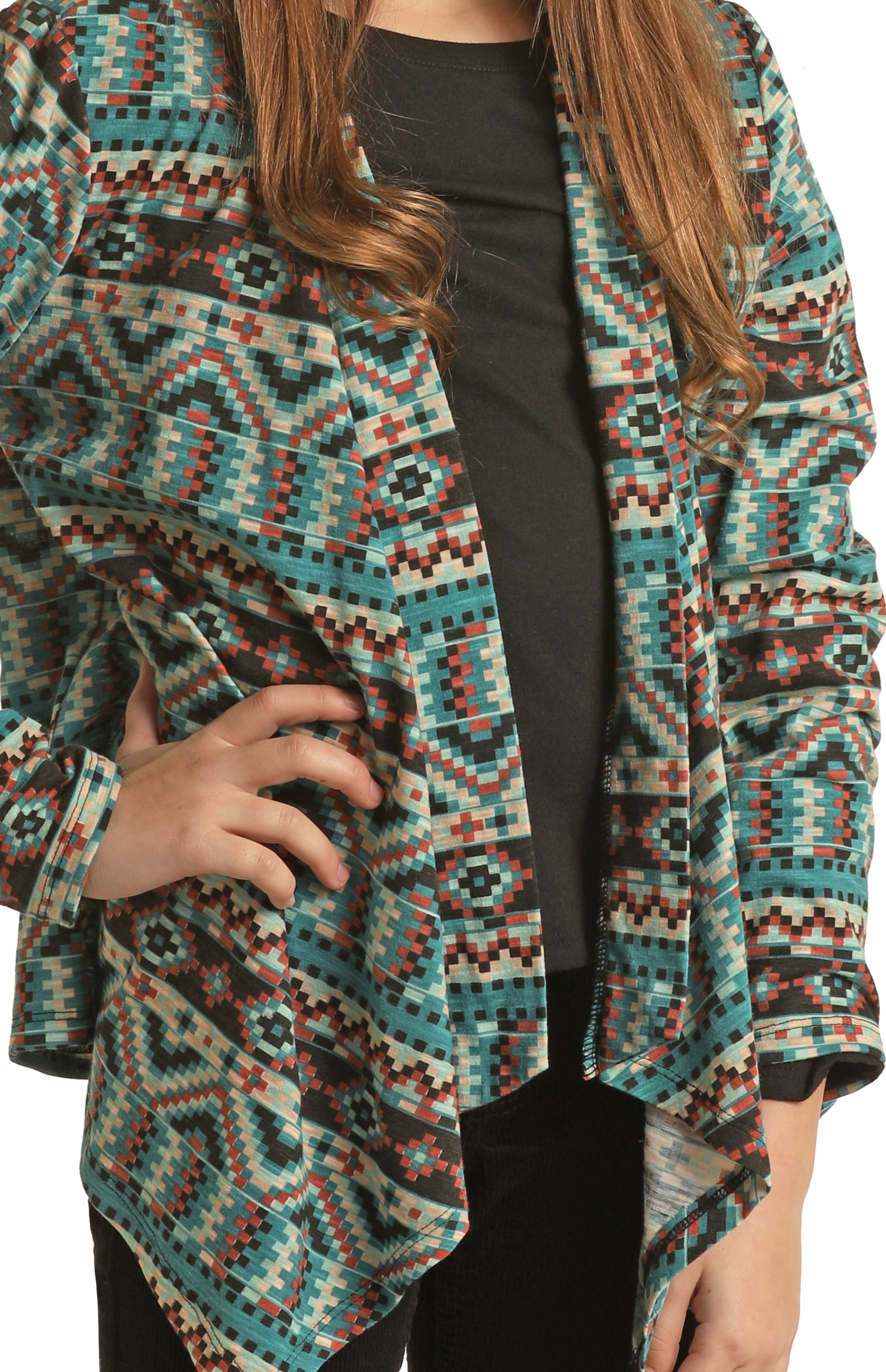 A person with long brown hair in a black top and a vibrant Rock & Roll Denim Girls' Aztec Print Cardigan stands with one hand on their hip, face not visible.