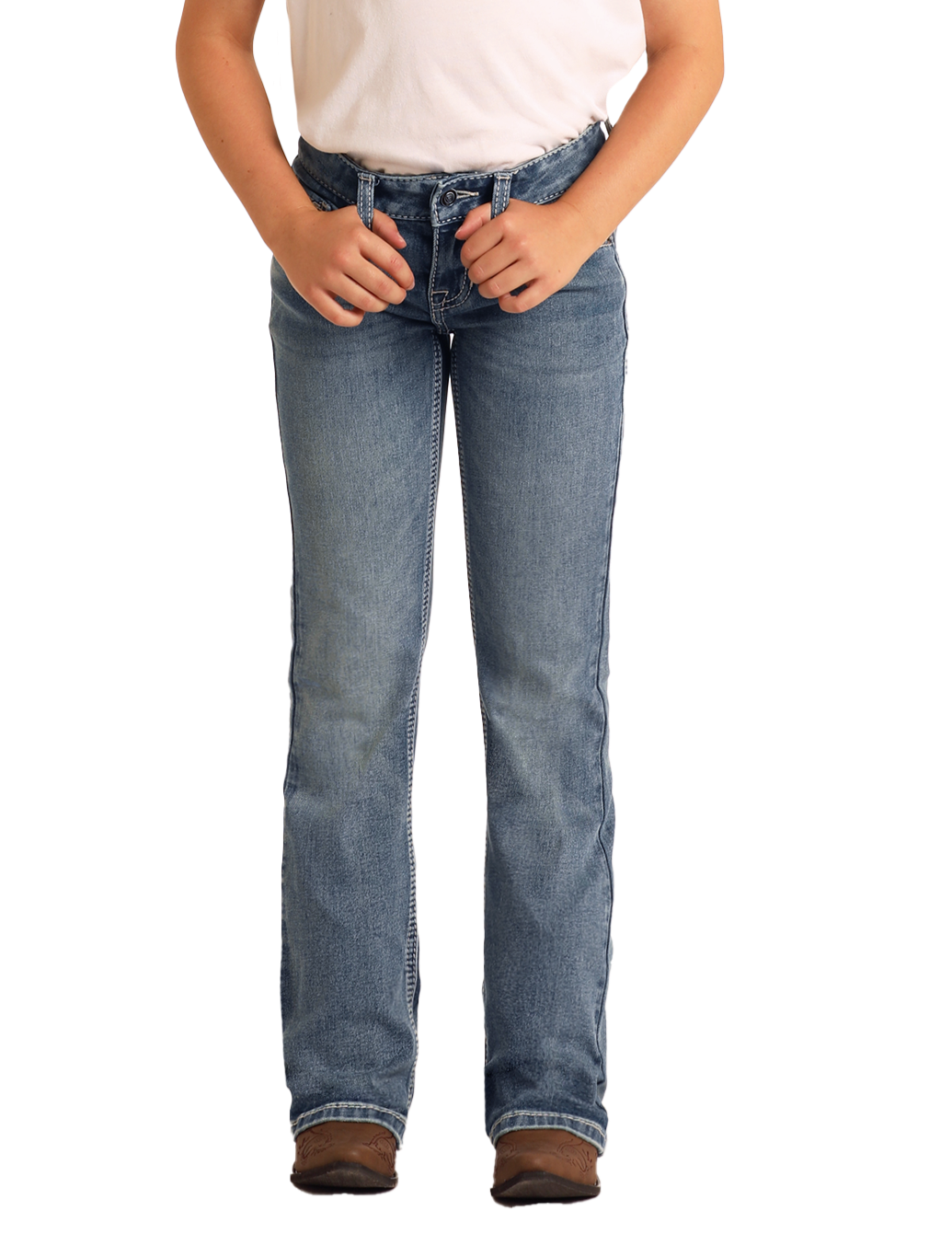 Wearing Rock & Roll Denim Girls' Mid Rise Steer Head Embroidered Bootcut Jeans in light blue with a white t-shirt and brown shoes, the person stands against a plain white background, hands on their belt loops, face not visible.