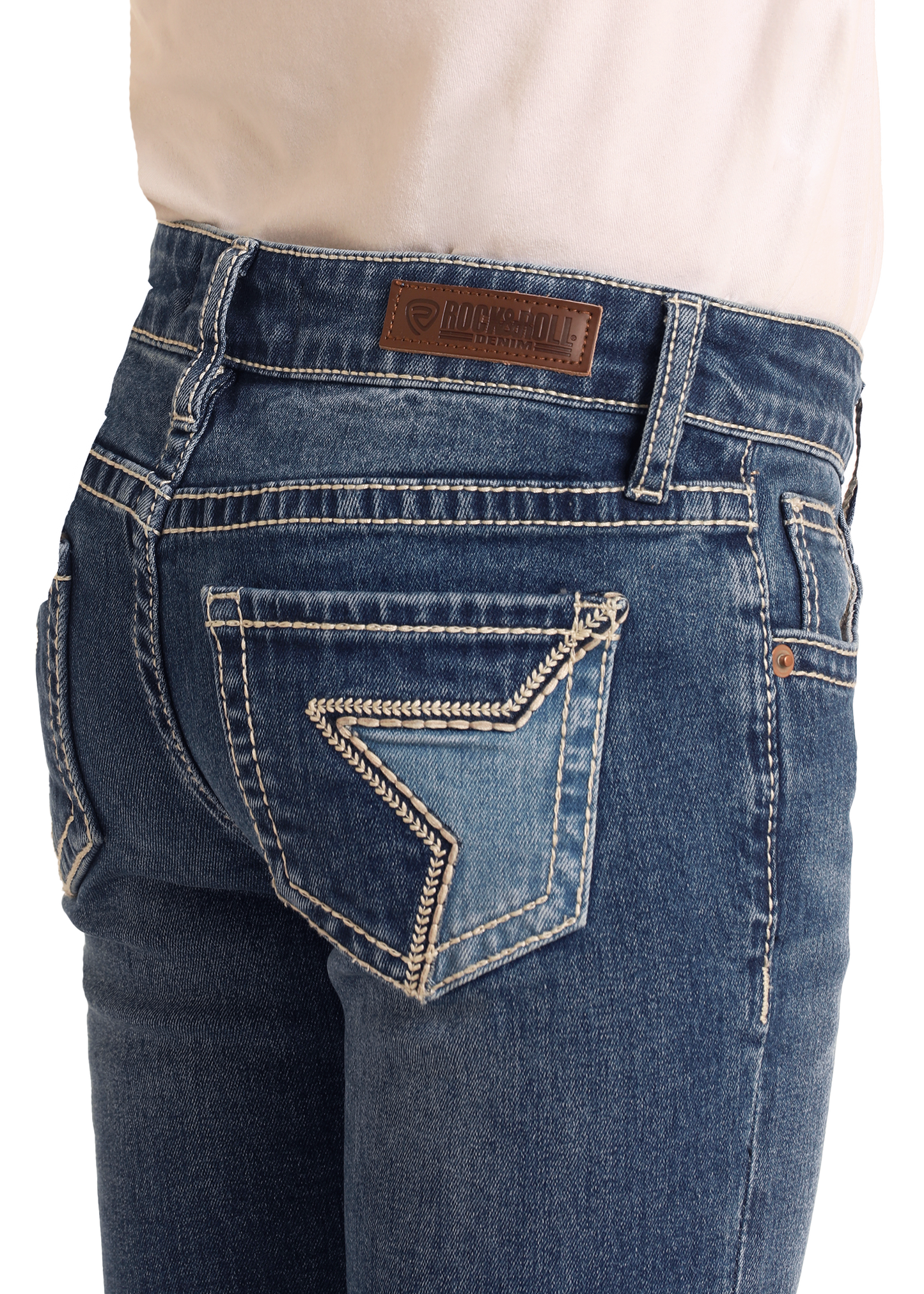 A close-up of a person wearing Rock & Roll Denim Girls' Embroidered Denim Star Bootcut Jeans, featuring white stitching, a decorative back pocket, and a brown leather brand patch on the waistband.