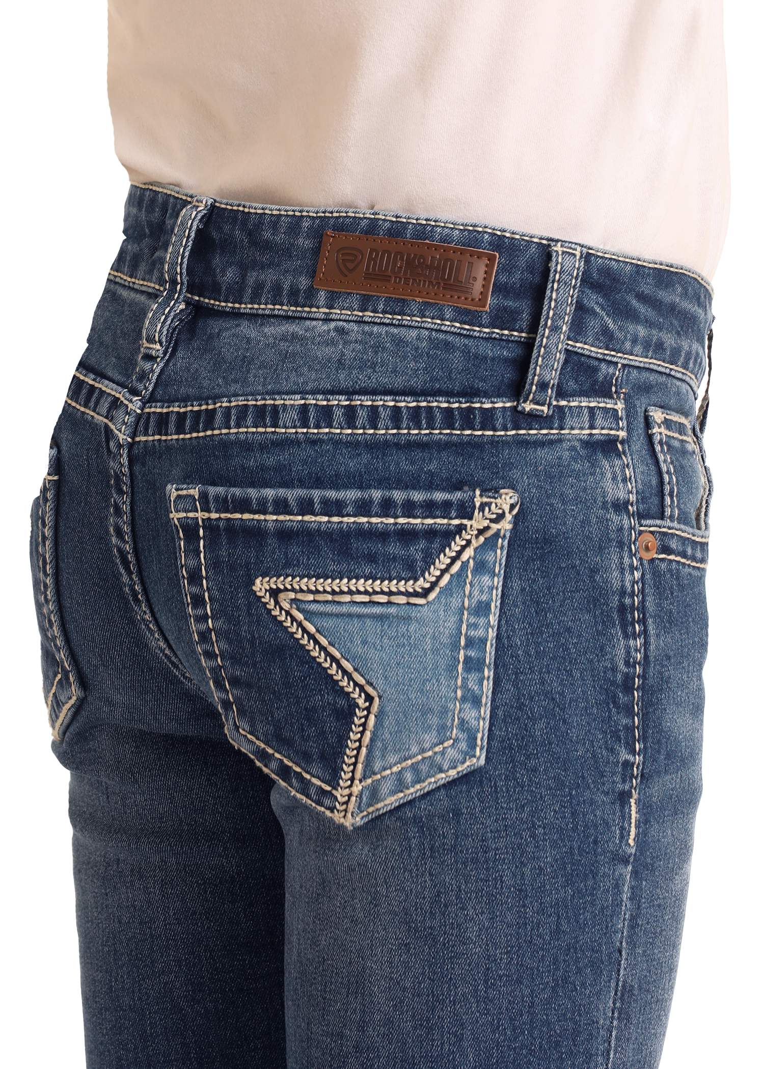 A close-up of a person wearing Rock & Roll Denim Girls' Embroidered Denim Star Bootcut Jeans, featuring white stitching, a decorative back pocket, and a brown leather brand patch on the waistband.