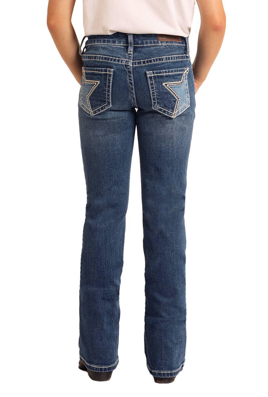 A girl wears Rock & Roll Denim Girls' Embroidered Denim Star Bootcut Jeans, featuring star embroidery on the back pockets, standing hands-in-pockets and facing away against a plain background.