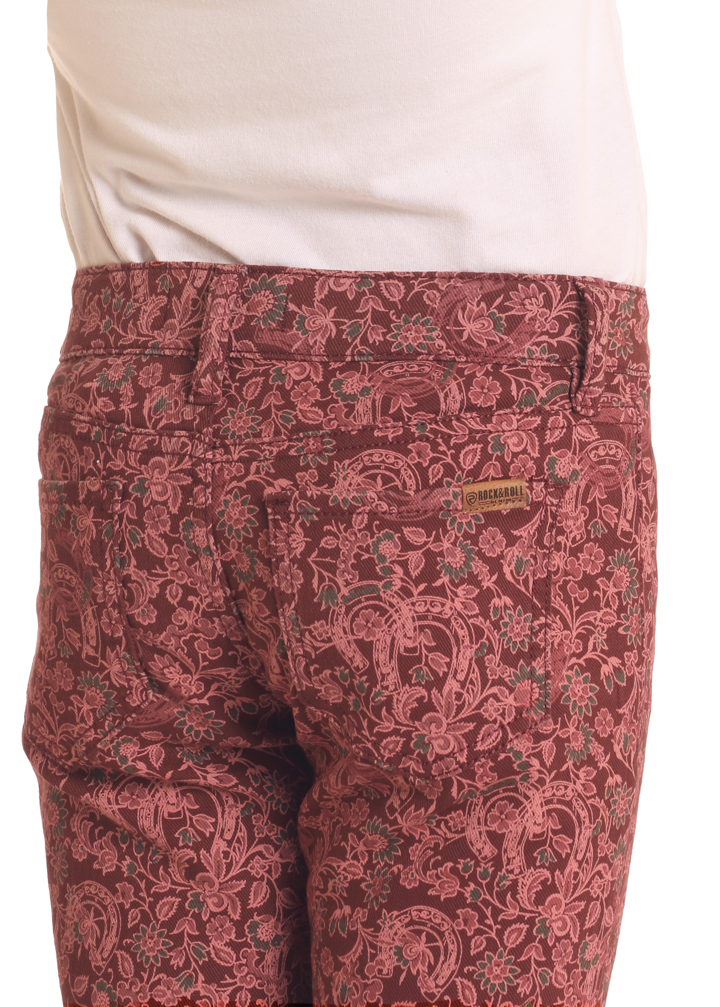 Close-up of a girl in Rock & Roll Denim Girls' Horseshoe Print Flare Jeans, featuring a pink horseshoe pattern and pale pink shirt tucked in. A small embroidered label sits above the right back pocket for added detail.