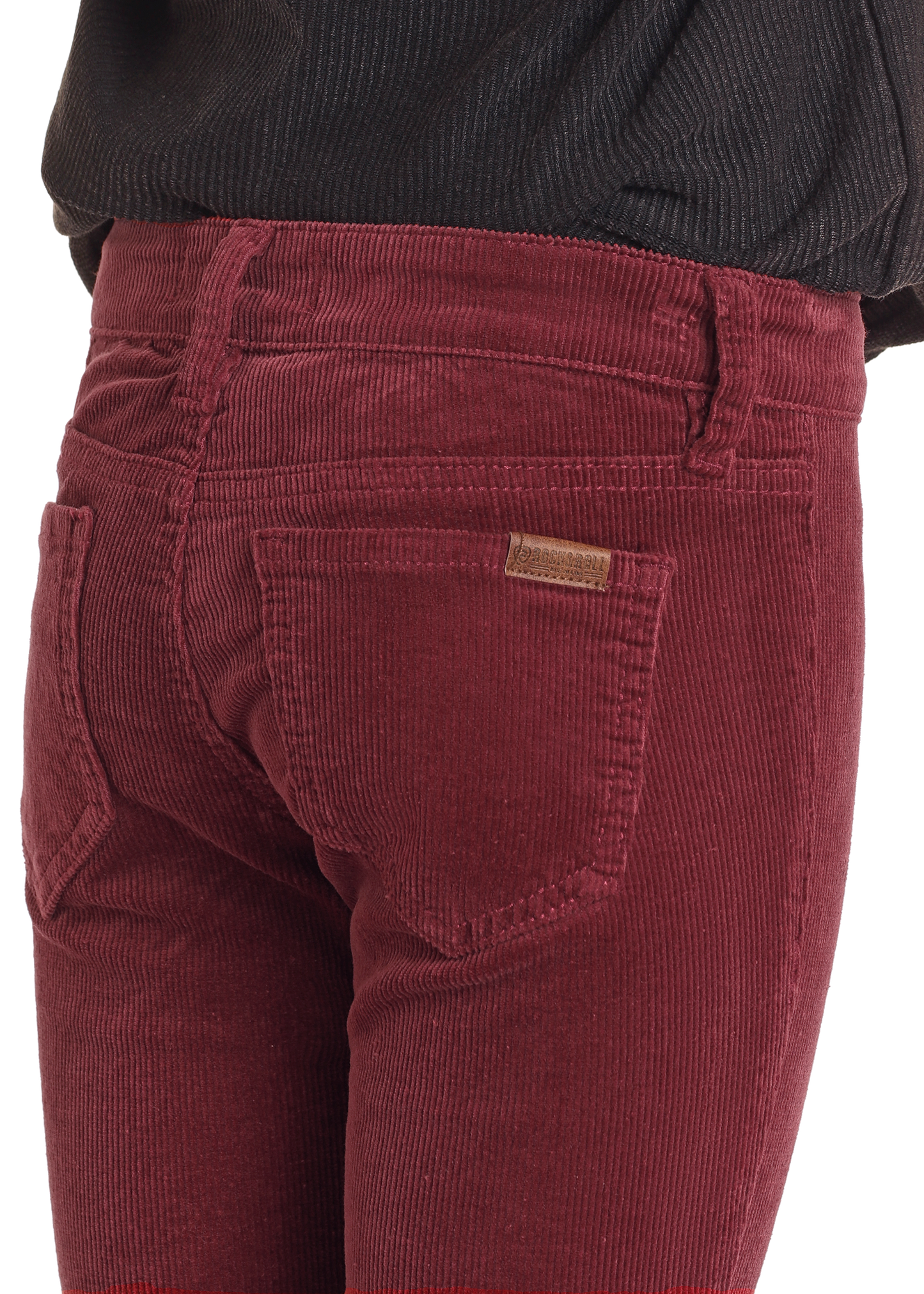 Close-up of a person wearing Rock & Roll Denim Girls' Maroon Corduroy Flare Jeans with a visible back pocket and small leather tag, styled with a black textured top for a cowgirl-inspired look.