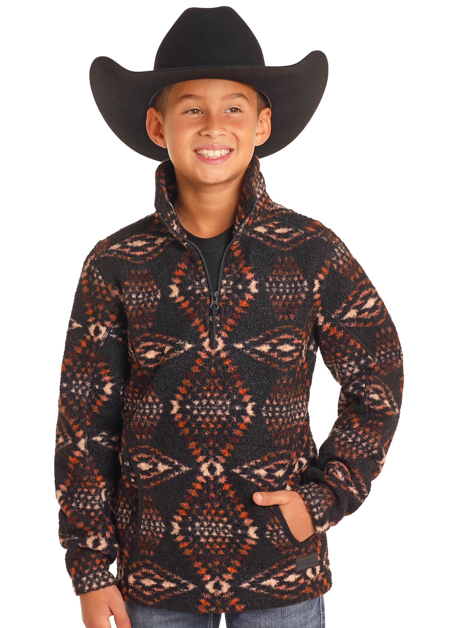 A smiling child in a black cowboy hat and Rock & Roll Denim Kids' Aztec Print Quarter Zip Pullover stands with hands in pockets against a plain white background.