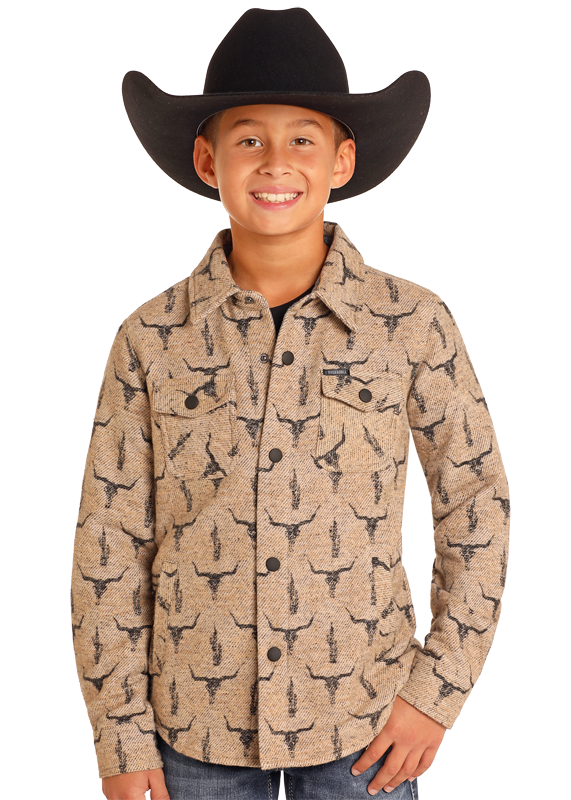 A smiling boy wears the Rock & Roll Denim Kids' Steer Skull Shirt Jacket, a black cowboy hat, and blue jeans, standing against a plain white background.
