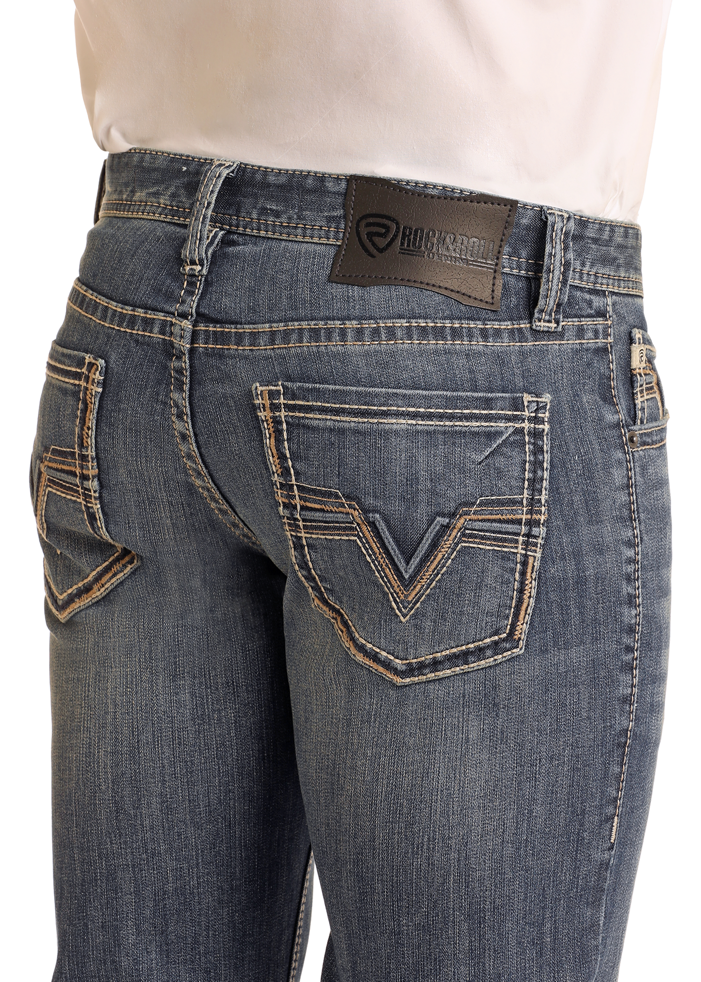 Close-up of the back of a person wearing Rock & Roll Denim Slim Fit Barb Wire Stitch Straight Leg Jeans in blue medium wash, featuring contrast stitching and a brand patch on the waistband. The jeans are paired with a tucked-in white shirt.