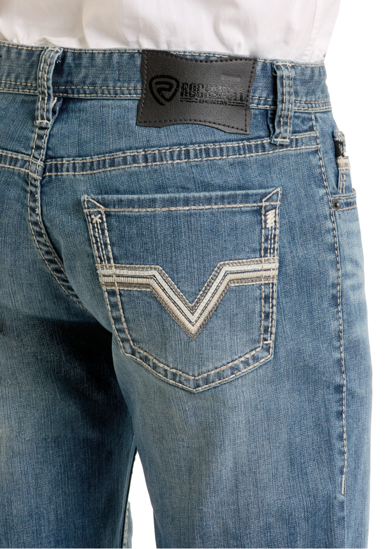 A close-up of the back of a person wearing Rock & Roll Denim Slim Fit Ladder Stitch Straight Leg Jeans with embroidered pockets, a black leather brand patch on the waistband, and a white tucked-in shirt.