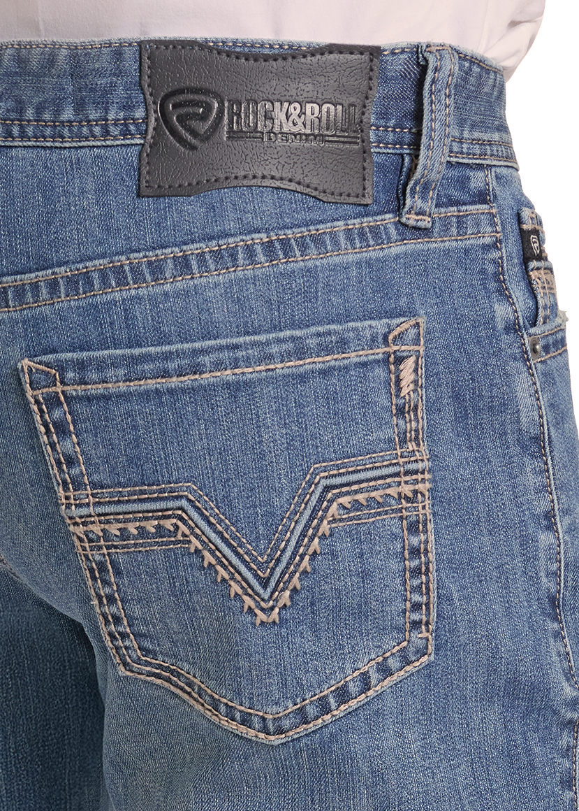 Close-up of the back waistband and pocket area of blue denim jeans, showing a dark gray Luck & Roll leather patch and decorative contrast stitching on the back pocket.