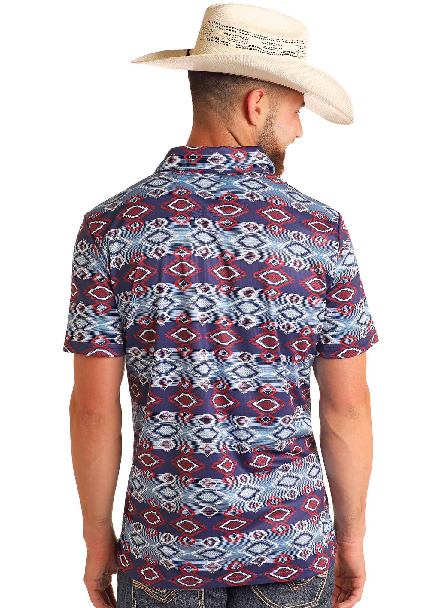 A man in a white cowboy hat and Rock & Roll Denim’s Navy Aztec Print Polo—featuring blue, red, and white geometric designs—is seen from the back against a plain white background.