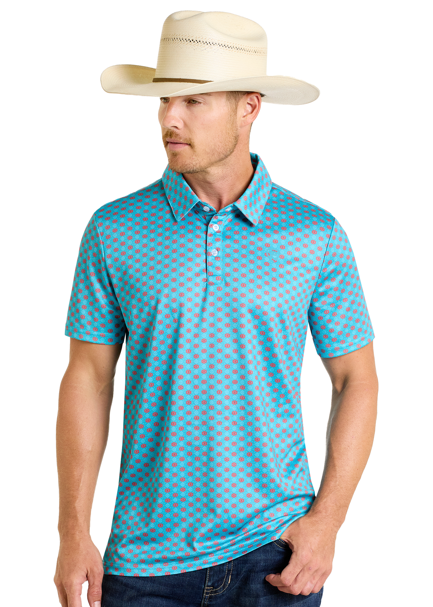 A man in a beige cowboy hat, dark jeans, and a Rock & Roll Denim Turquoise Geo Print Polo with a red geometric pattern stands against a plain light background.