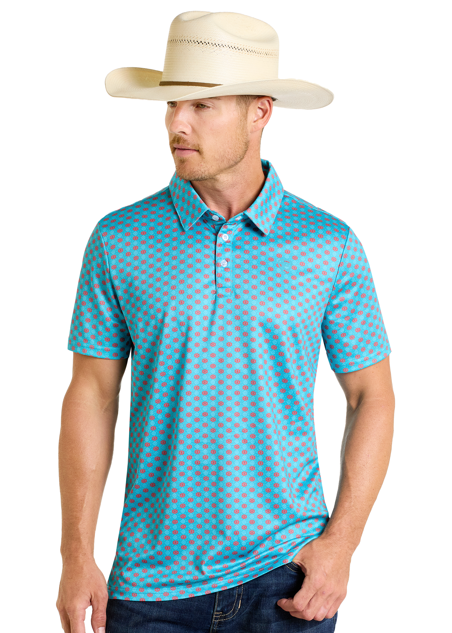 A man in a beige cowboy hat, dark jeans, and a Rock & Roll Denim Turquoise Geo Print Polo with a red geometric pattern stands against a plain light background.