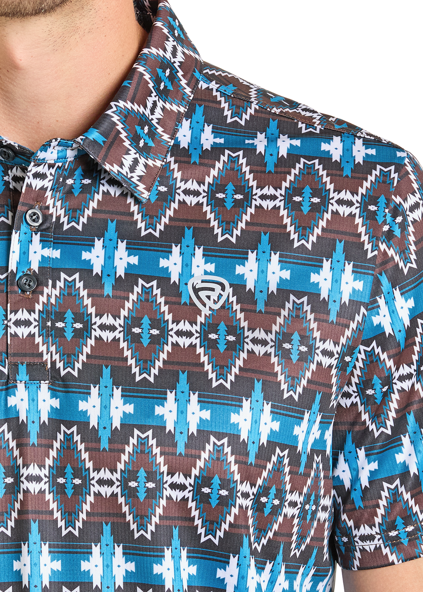 Close-up of the Rock & Roll Denim Brown & Blue Aztec Polo, a casual regular fit shirt featuring a geometric Southwestern-inspired pattern in blue, white, and brown. Only the shirt and part of the wearer’s neck and chin are visible.
