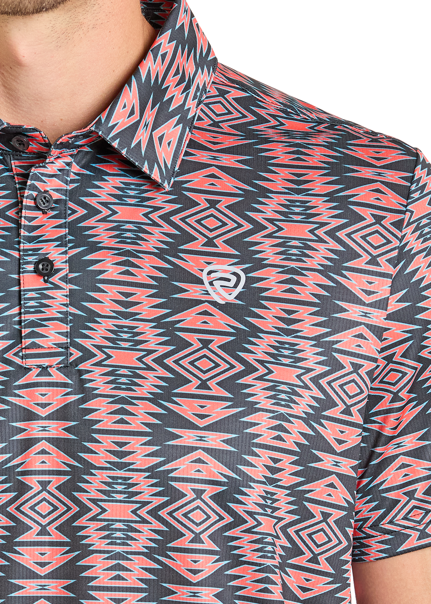 A close-up of the Rock & Roll Denim Aztec Tiger Polo, a regular fit shirt with a bold red, white, and blue geometric pattern and small white chest logo; the lower half of a person's face and neck are partially visible. Casual yet striking.