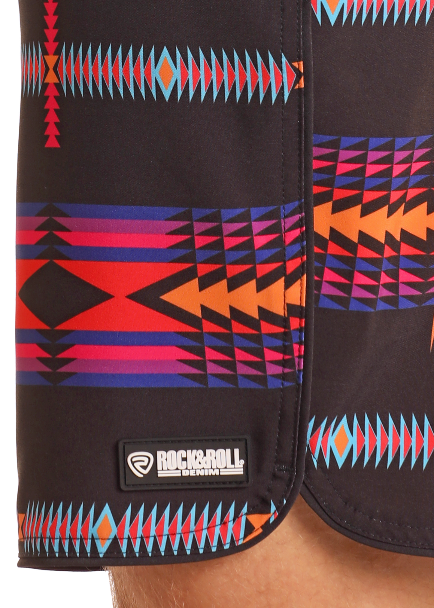 Close-up of Black Aztec Board Shorts by Rock & Roll Denim, featuring a vibrant geometric pattern in orange, red, purple, and blue—perfect swimwear for making a bold statement.