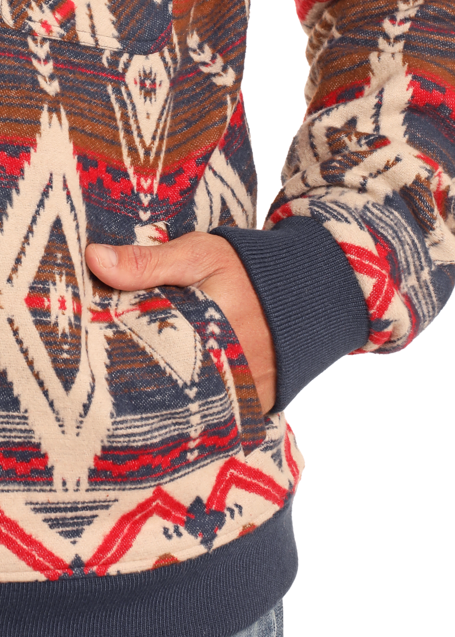 Someone in a Rock & Roll Denim Aztec Jacquard Bomber Pullover with blue cuffs has their right hand in the front pocket; only their torso and part of their arm are visible.