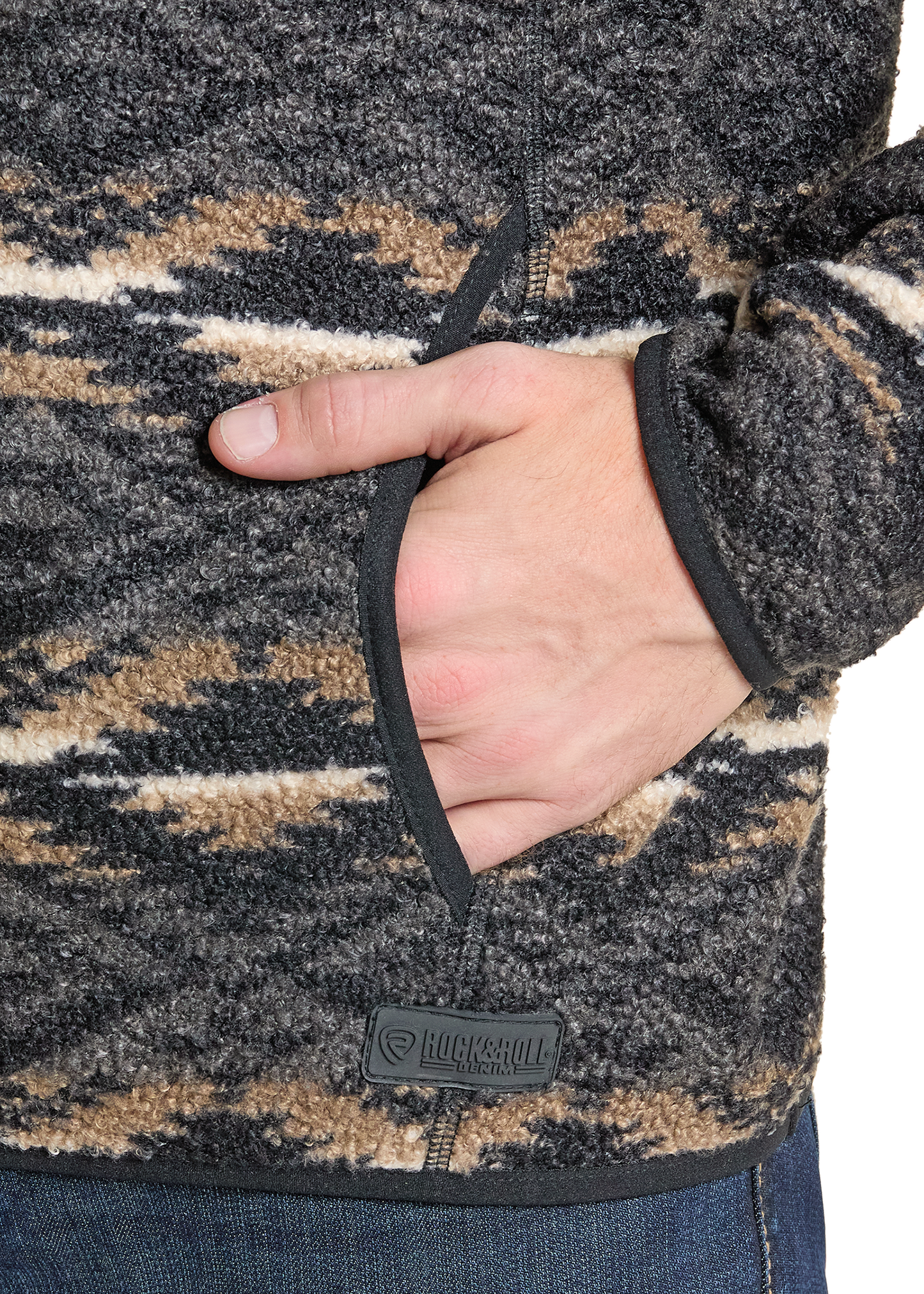Close-up of a hand in a patterned fleece jacket with a visible brand logo.