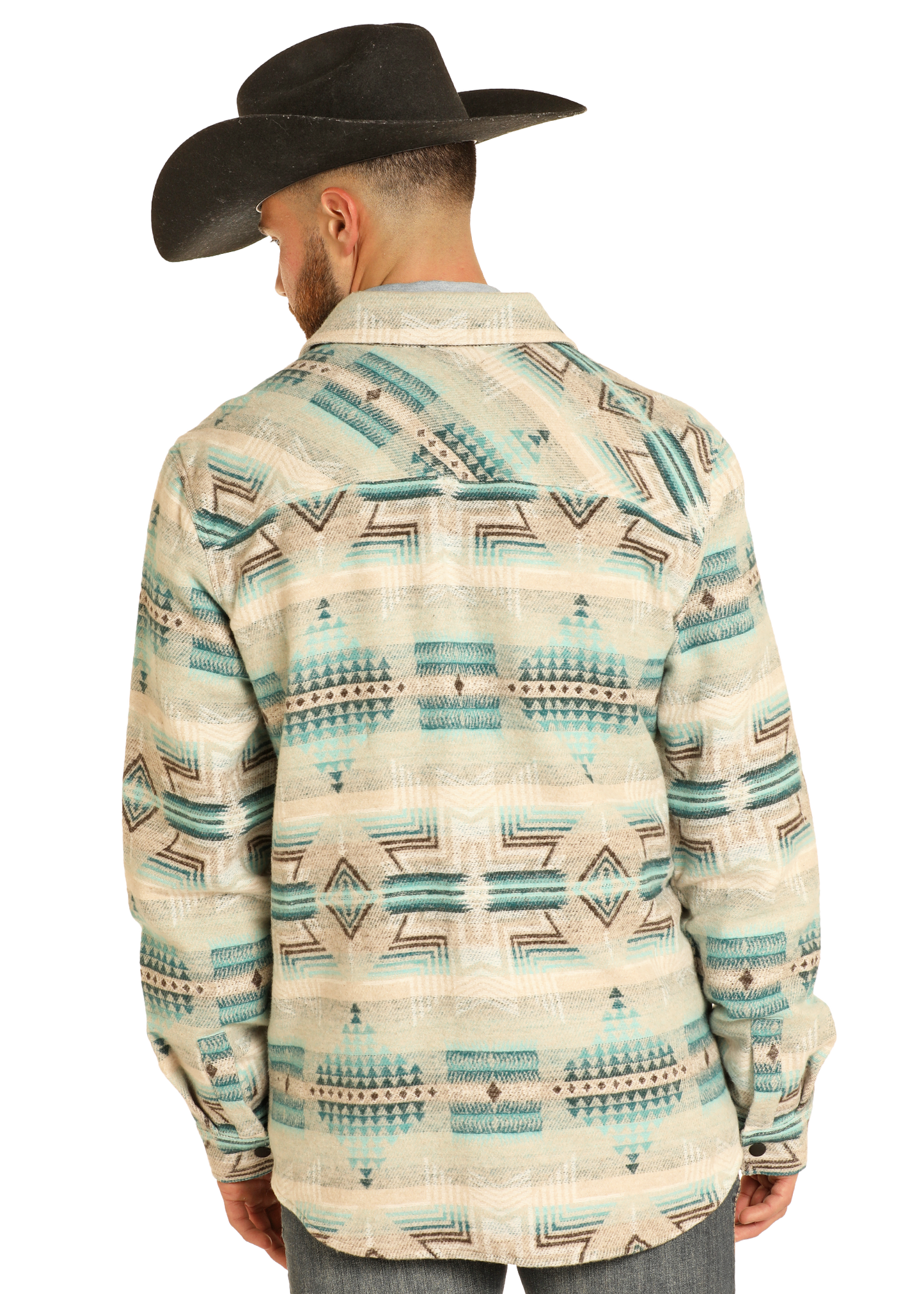 A man wearing a black cowboy hat and the Rock & Roll Denim Aztec Print Jacquard Shirt Jacket stands with his back to the camera, showcasing its cream fabric with teal and beige geometric designs against a plain background.