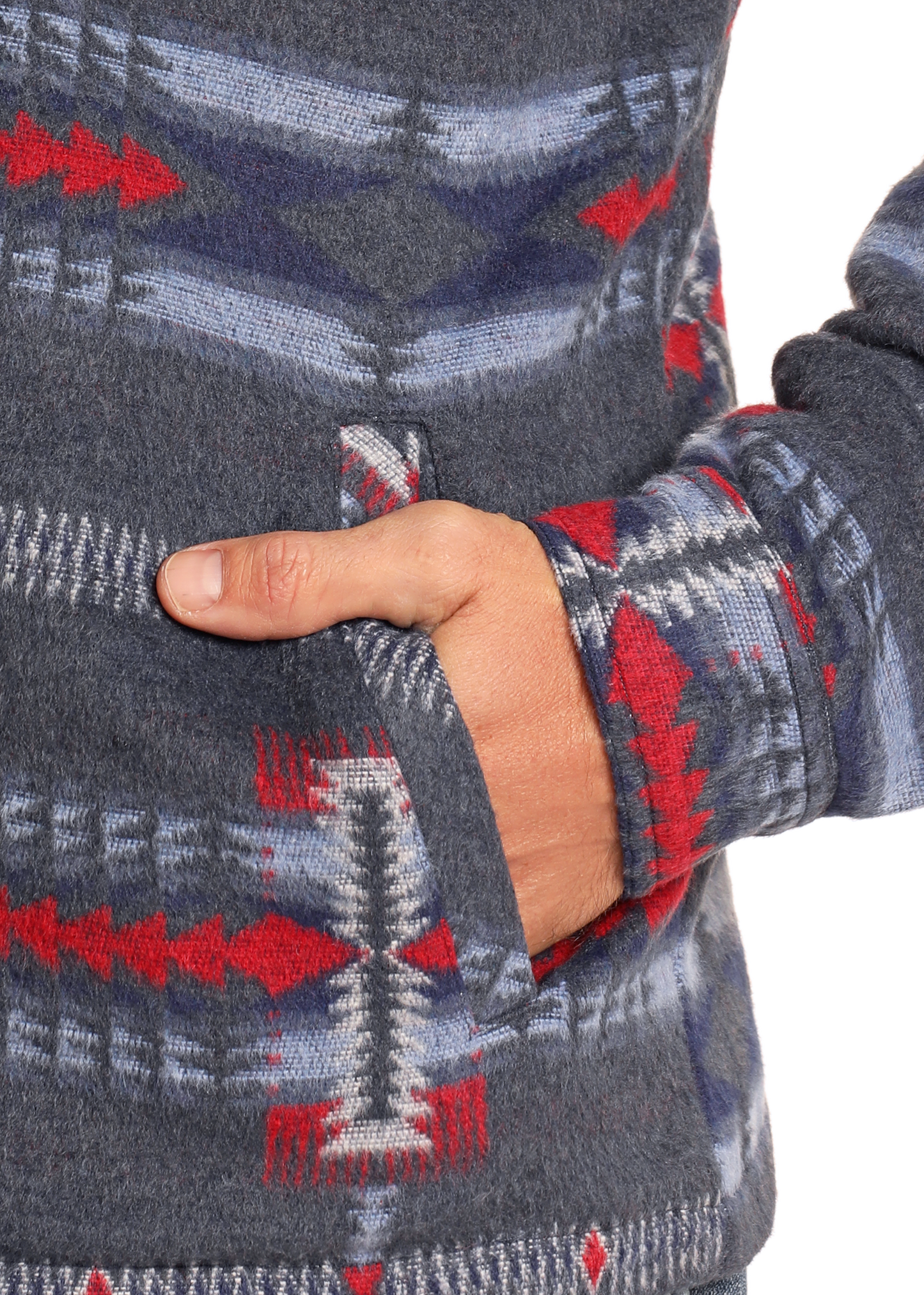 A close-up of a hand partially tucked into the pocket of the Rock & Roll Denim Blue Aztec Brushed Jacquard Zip Up Jacket, featuring red, blue, and white geometric patterns.