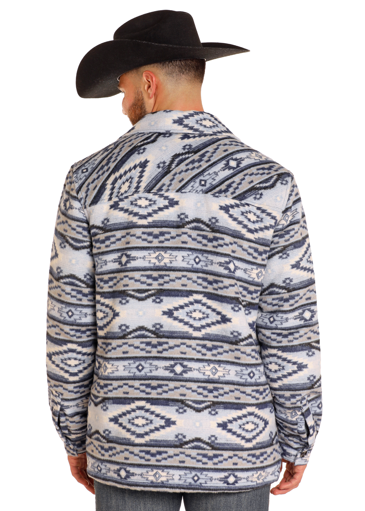 A man in a black cowboy hat stands facing away, wearing the Rock & Roll Denim Aztec Brushed Jacquard Shirt Jacket with geometric patterns and a sherpa lining.