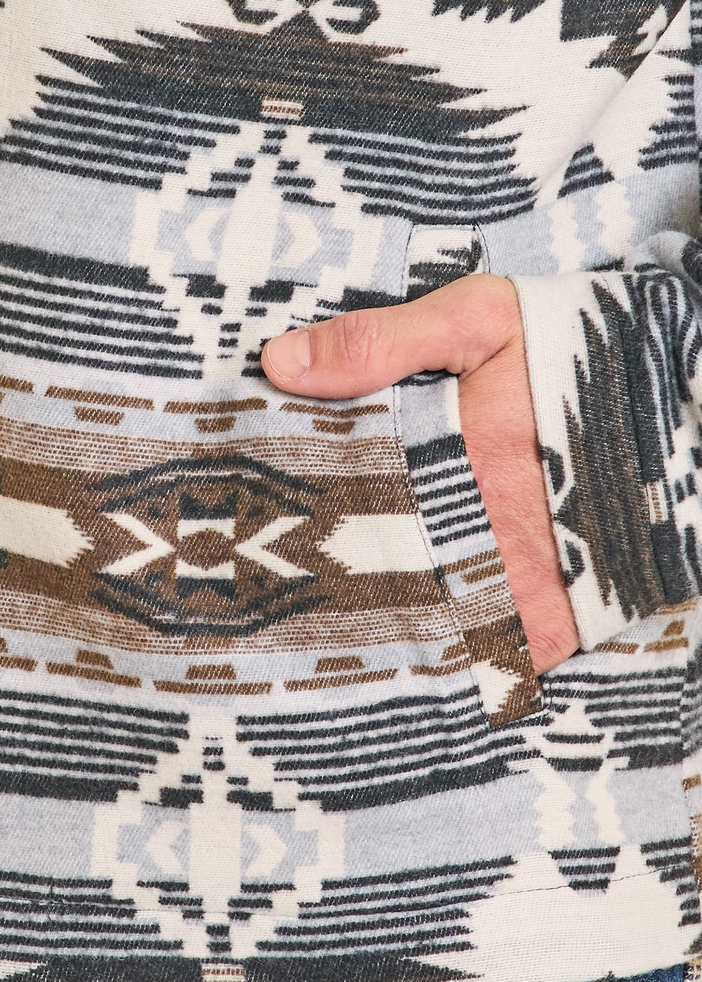Close-up of a hand with a patterned fabric background
