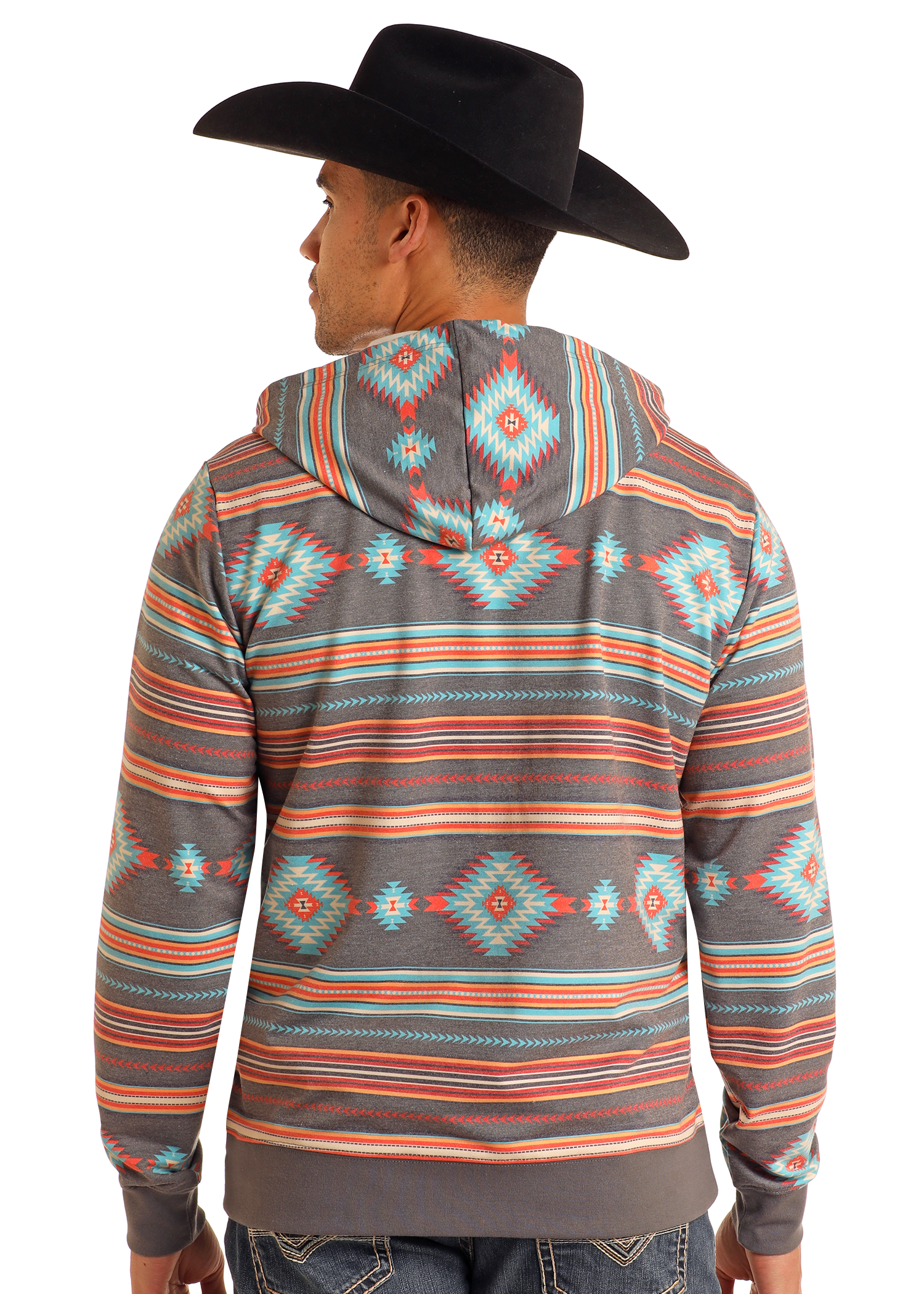 A man wearing a black cowboy hat and a Rock & Roll Denim Grey Aztec Print Hoodie with bold southwestern geometric designs stands facing away, highlighting the vibrant back of the hoodie.