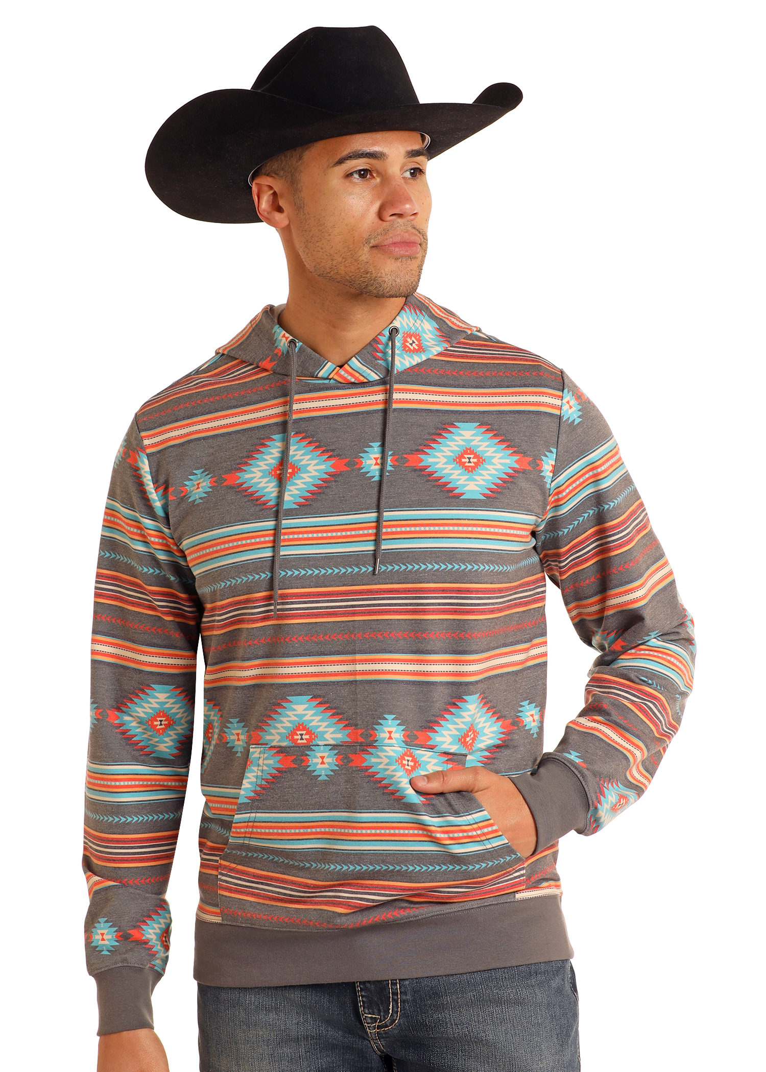 A man wearing a black cowboy hat and a Rock & Roll Denim Grey Aztec Print Hoodie featuring vibrant orange, teal, and gray geometric designs stands with one hand in his pocket, looking to the side.