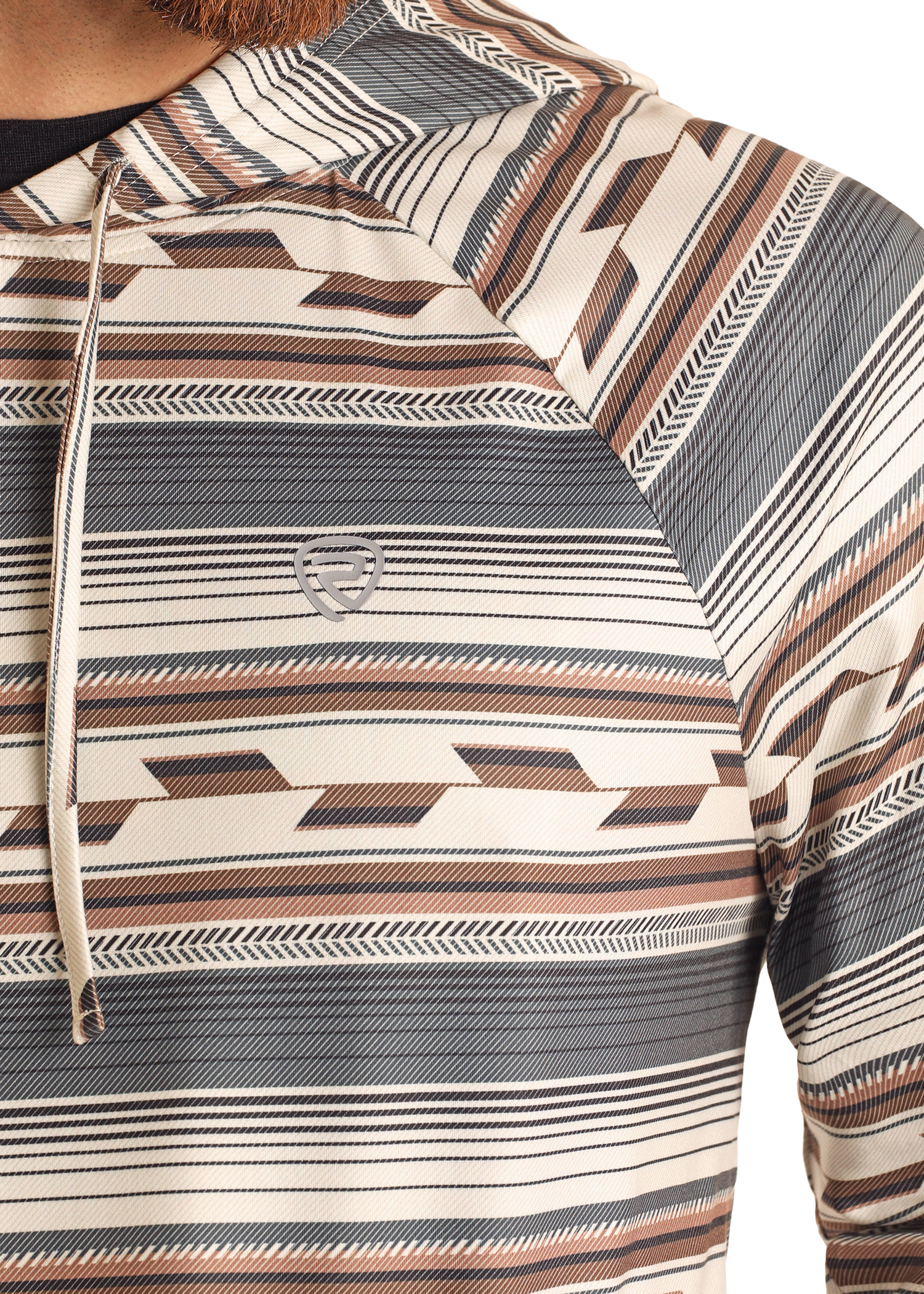 Close-up of a person wearing the Rock & Roll Denim Multi Stripe Performance Hoodie, featuring beige, brown, and black horizontal geometric stripes, a small chest logo, and comfortable stretch fabric. Only the upper torso and part of an arm are shown.