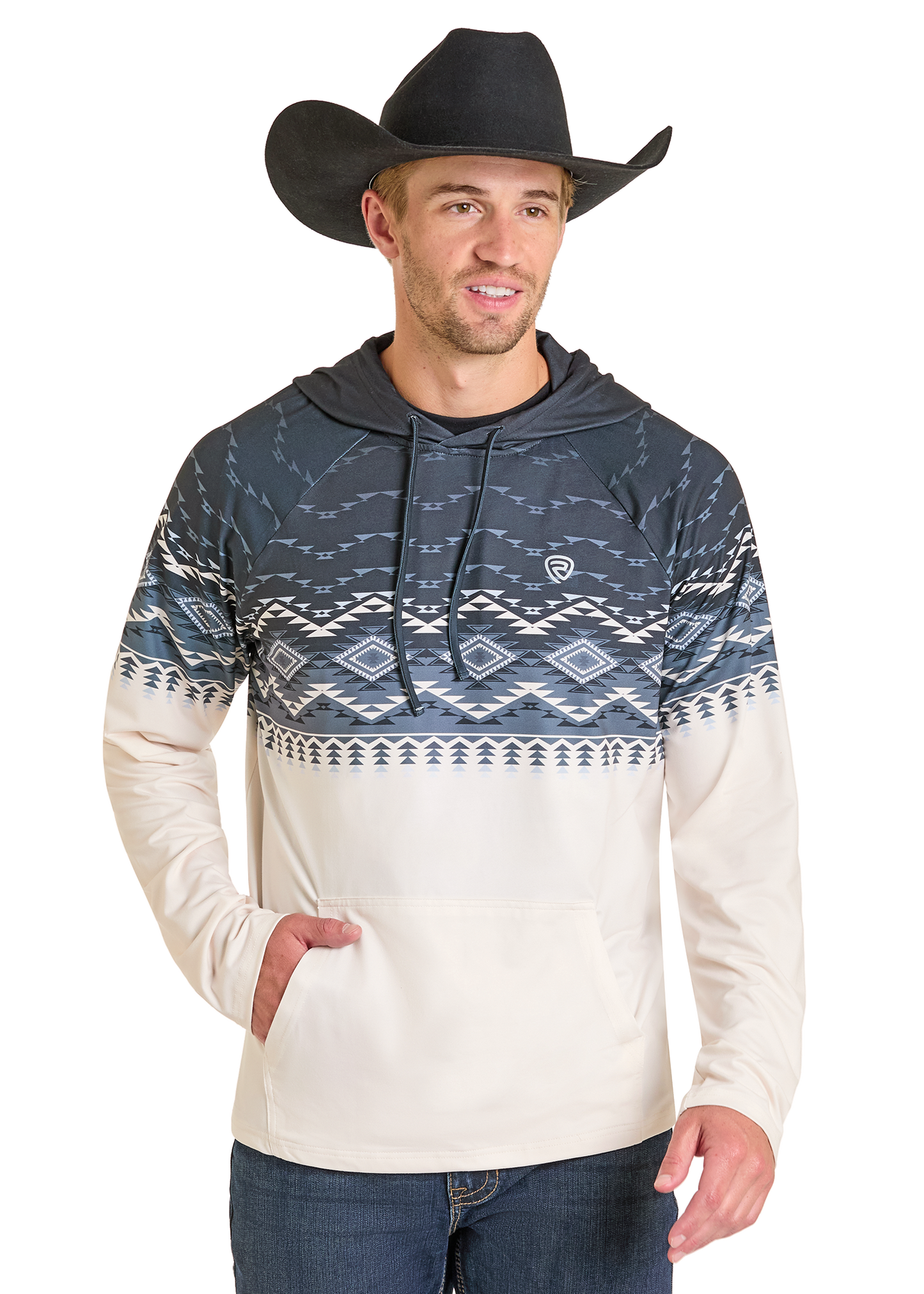 A man in a black cowboy hat, blue jeans, and the Rock & Roll Denim Aztec Top Performance Hoodie featuring dark and light Aztec designs stands against a white background, smiling slightly and looking to the side.