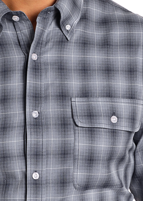 Close-up of a person wearing the Rock & Roll Denim Slim Fit Indigo Plaid Long Sleeve Button Down Shirt, featuring white buttons, a left front pocket, and subtle black and white plaid patterns.