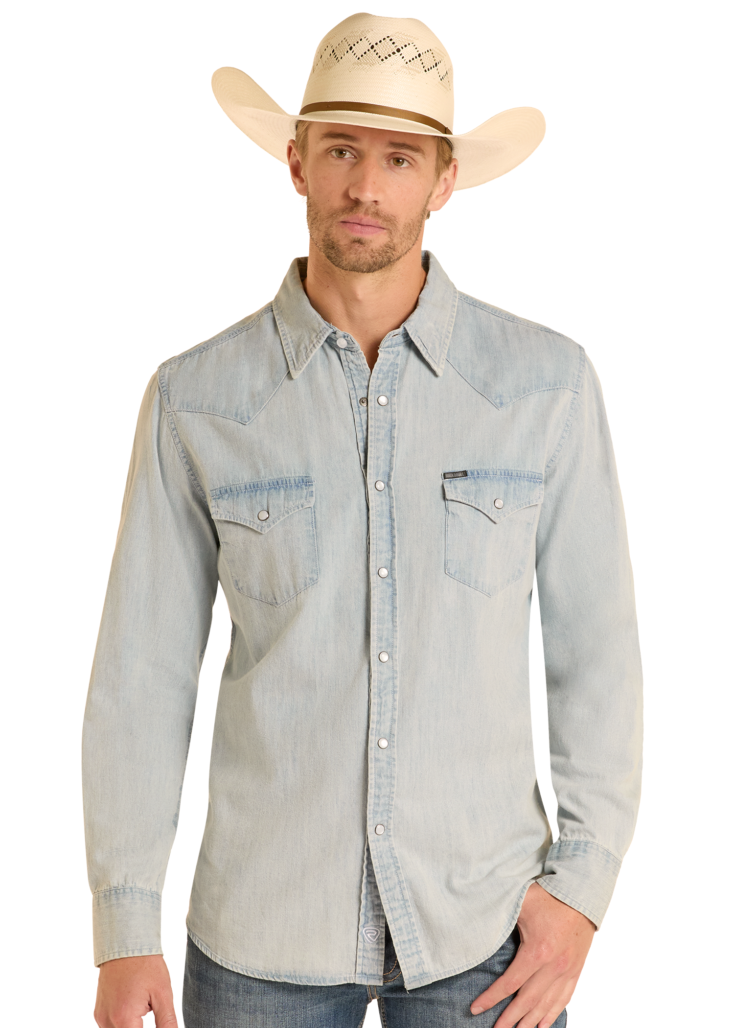 A man in a Rock & Roll Denim Slim Fit Light Wash Denim Snap Shirt with dual chest pockets and long sleeves, wearing a light cowboy hat, stands against a plain white background.