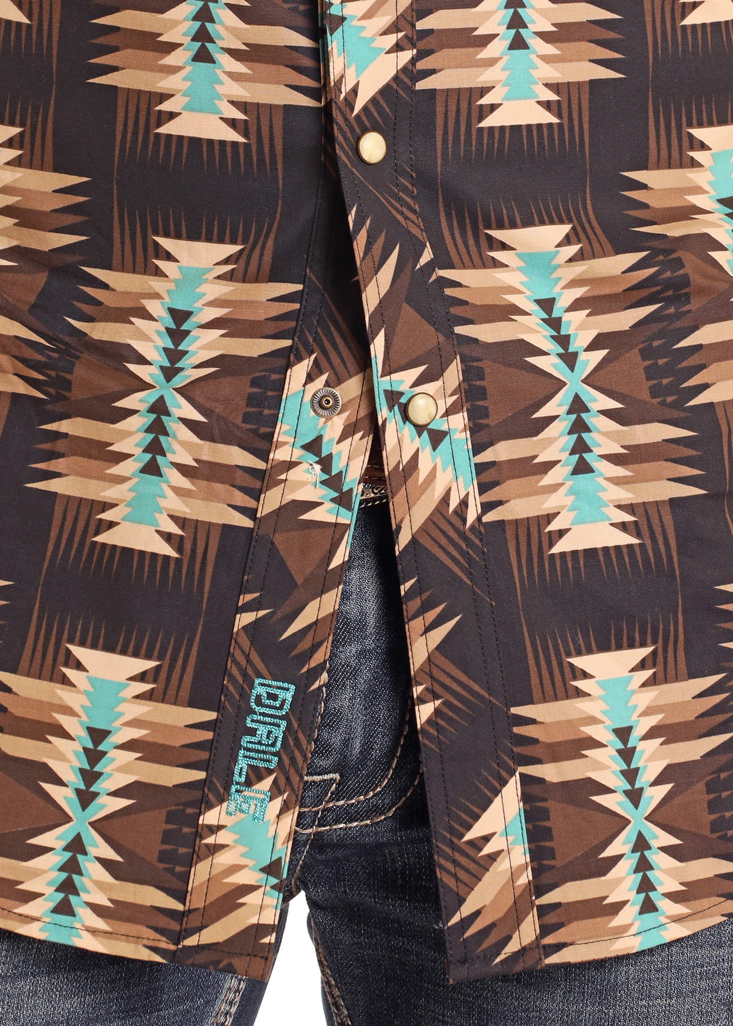 A close-up of a Dale Brisby Slim Fit Brown Aztec Long Sleeve Snap Shirt by Rock & Roll Denim, featuring a geometric tribal pattern and worn partially unbuttoned over blue denim jeans for standout style.