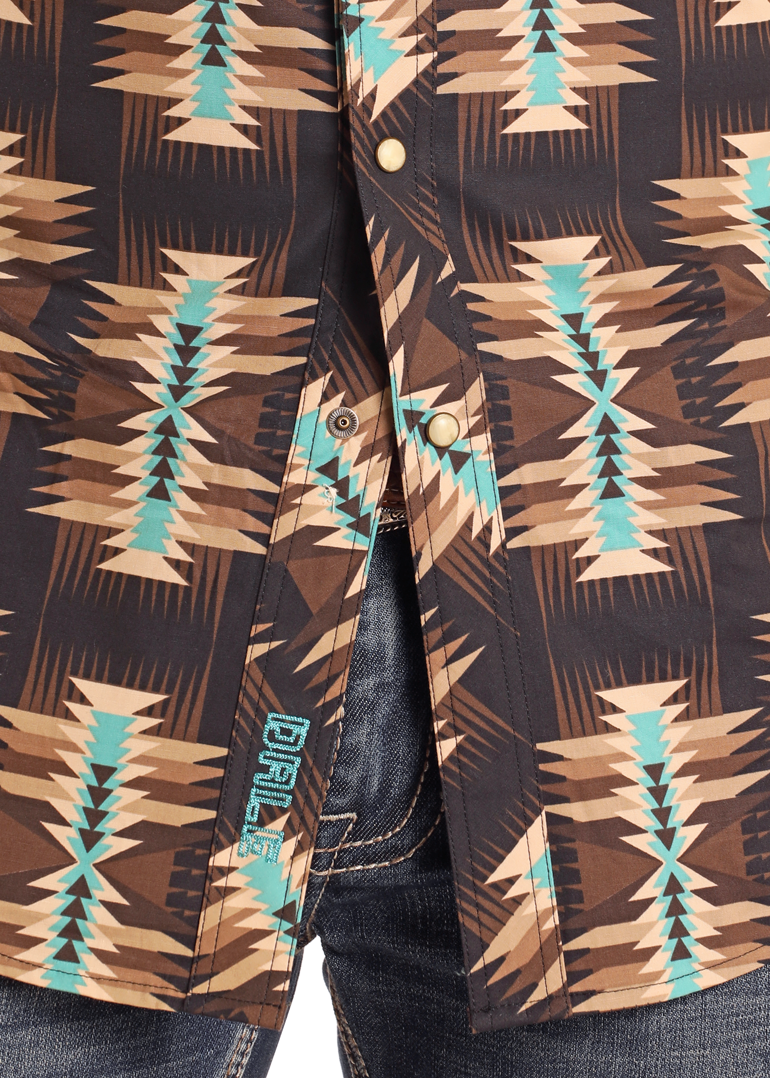 A close-up of a Dale Brisby Slim Fit Brown Aztec Long Sleeve Snap Shirt by Rock & Roll Denim, featuring a geometric tribal pattern and worn partially unbuttoned over blue denim jeans for standout style.