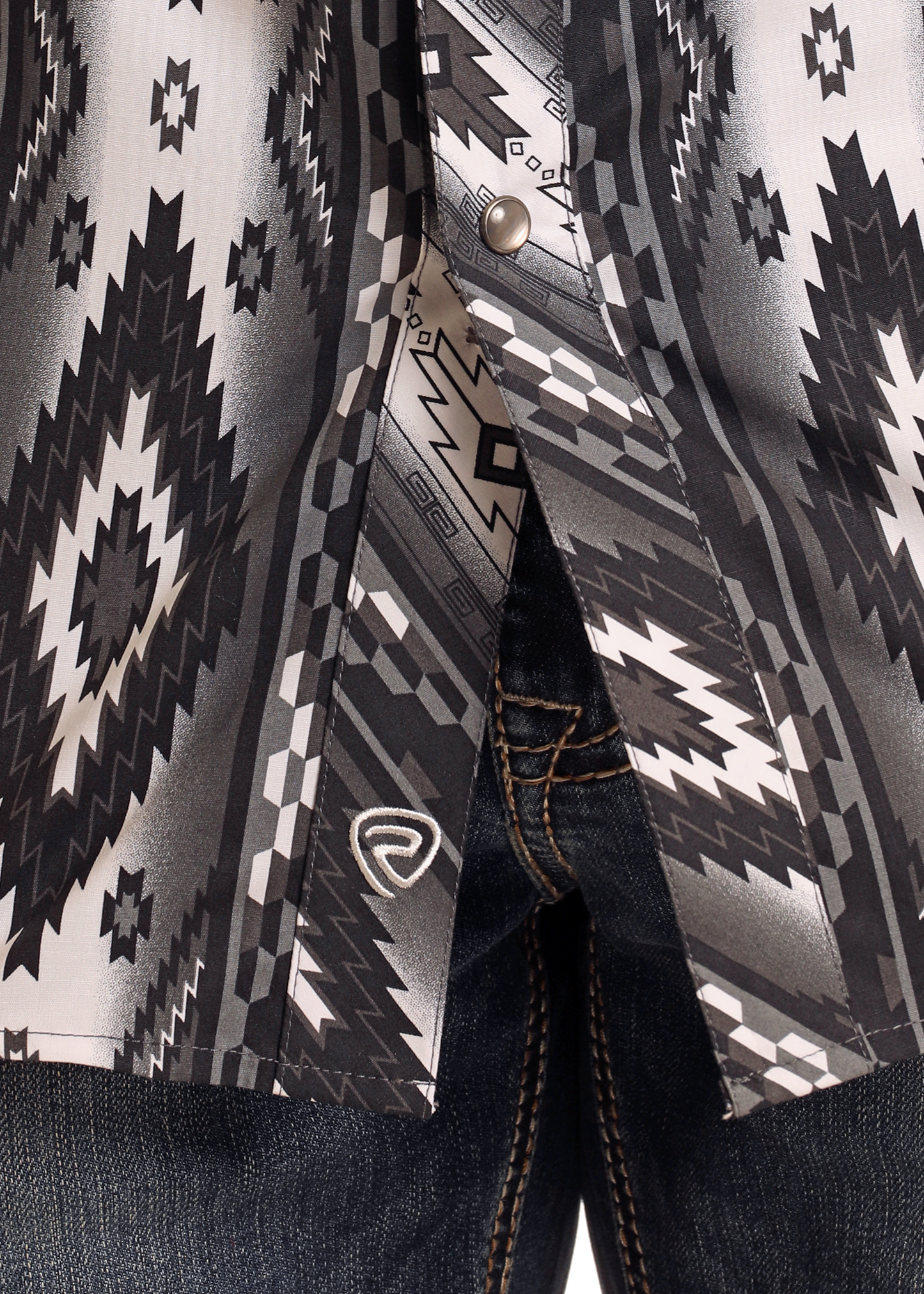 Close-up of the Rock & Roll Denim Slim Fit Black Southwestern Long Sleeve Snap Shirt, partially unbuttoned and paired with dark blue jeans featuring visible orange stitching.