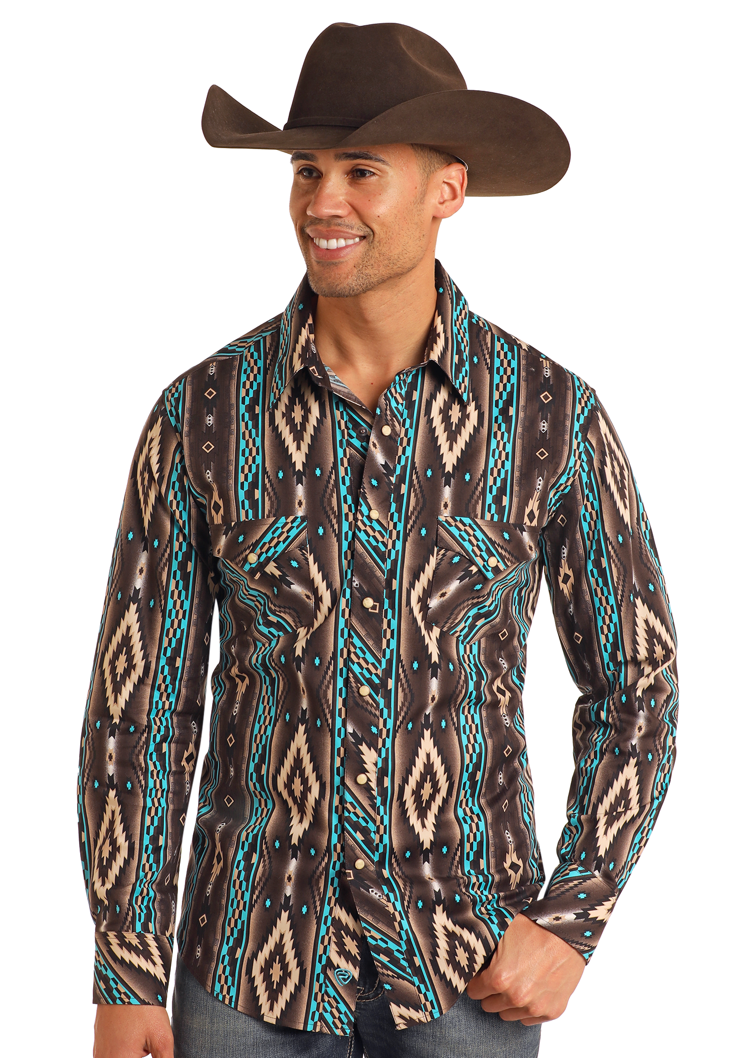 A smiling man in a Rock & Roll Denim Slim Fit Southwestern Striped Long Sleeve Snap Shirt, featuring turquoise, tan, and black geometric designs, stands casually with one hand in his pocket, wearing a cowboy hat and blue jeans.