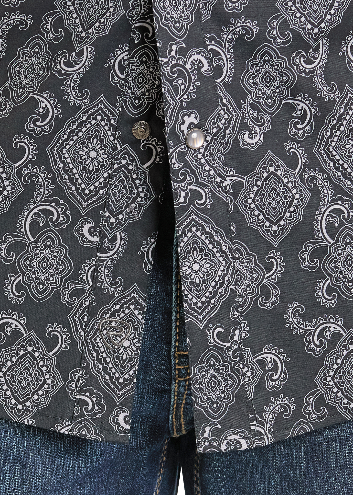 Closeup of a pattered pearl snap shirt.